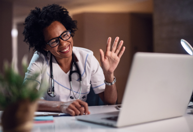 A doctor waving to a patient on a digital call
