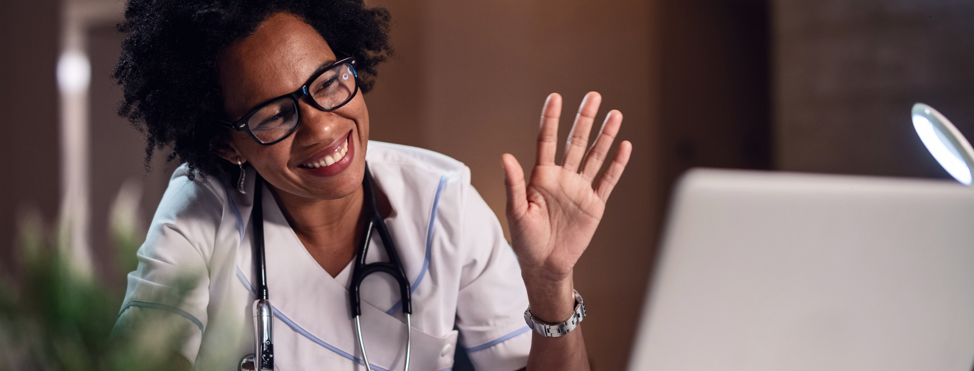 A doctor waving to a patient on a digital call