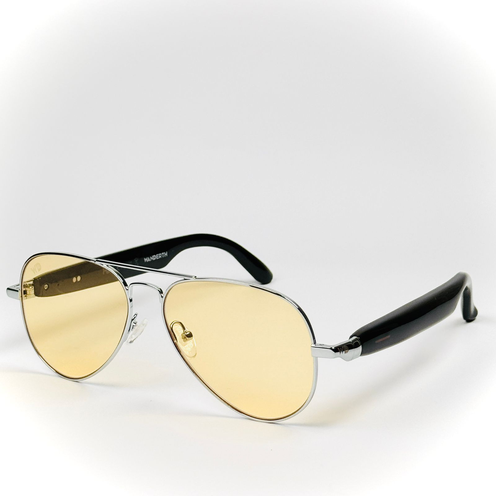 Gafas de sol de aviador con lentes amarillas y patillas negras.