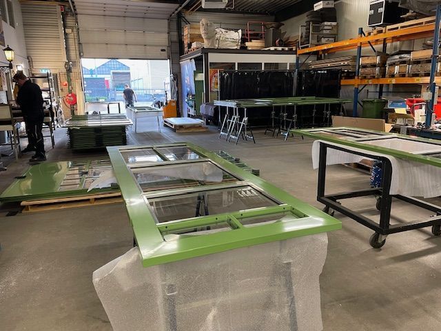 Een man werkt op een groene tafel in een fabriek.