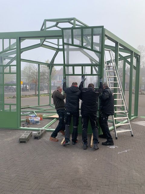 Een groep mannen werkt aan een kas