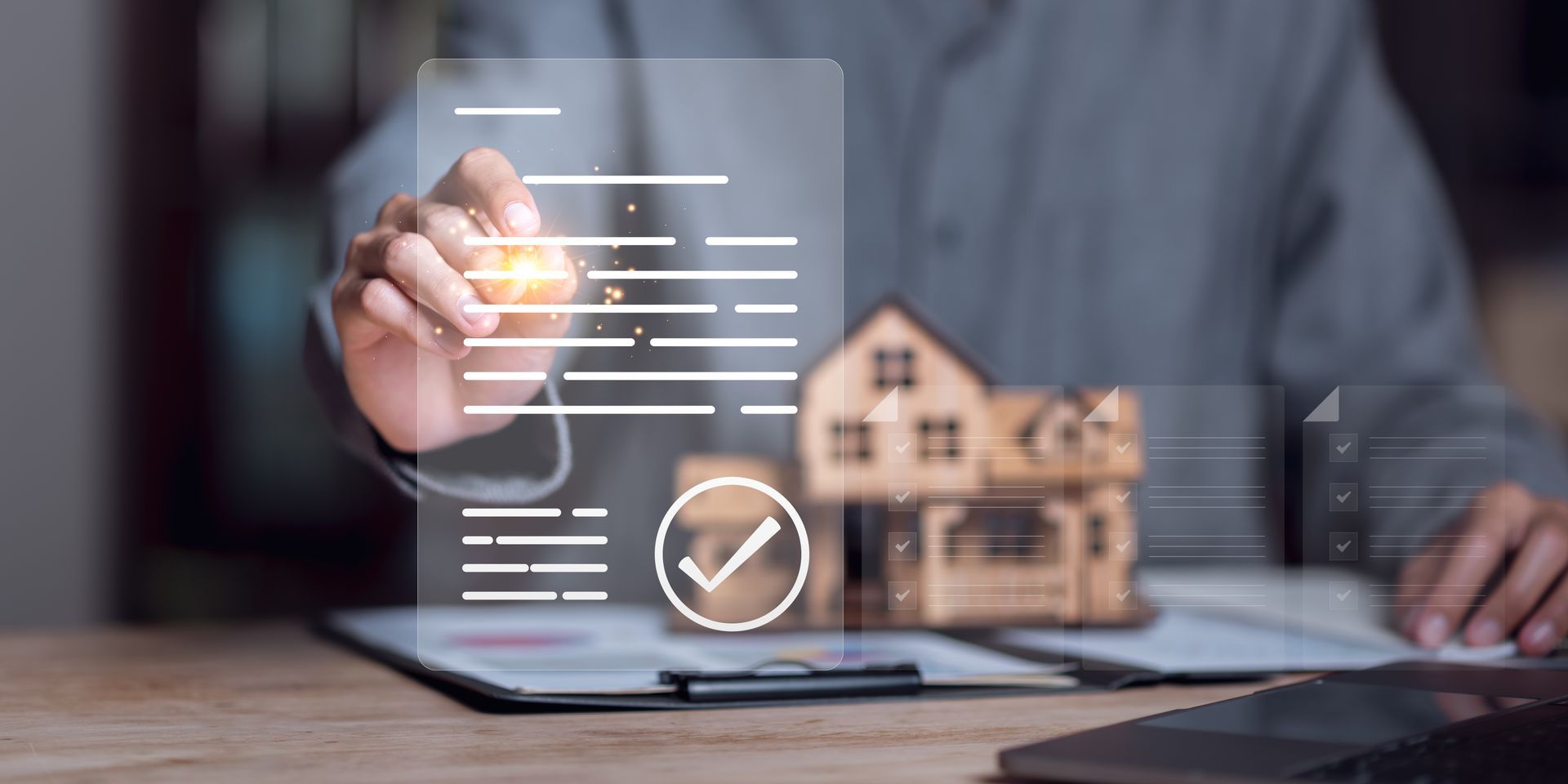Hand touching a digital house model with checkmark overlay on a desk, suggesting home inspection or smart real estate