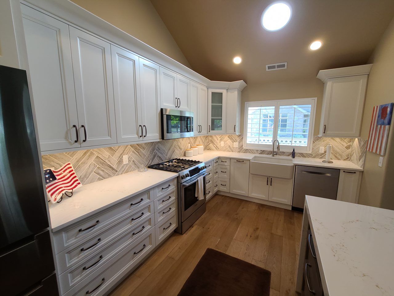 A kitchen with white cabinets and stainless steel appliances.
