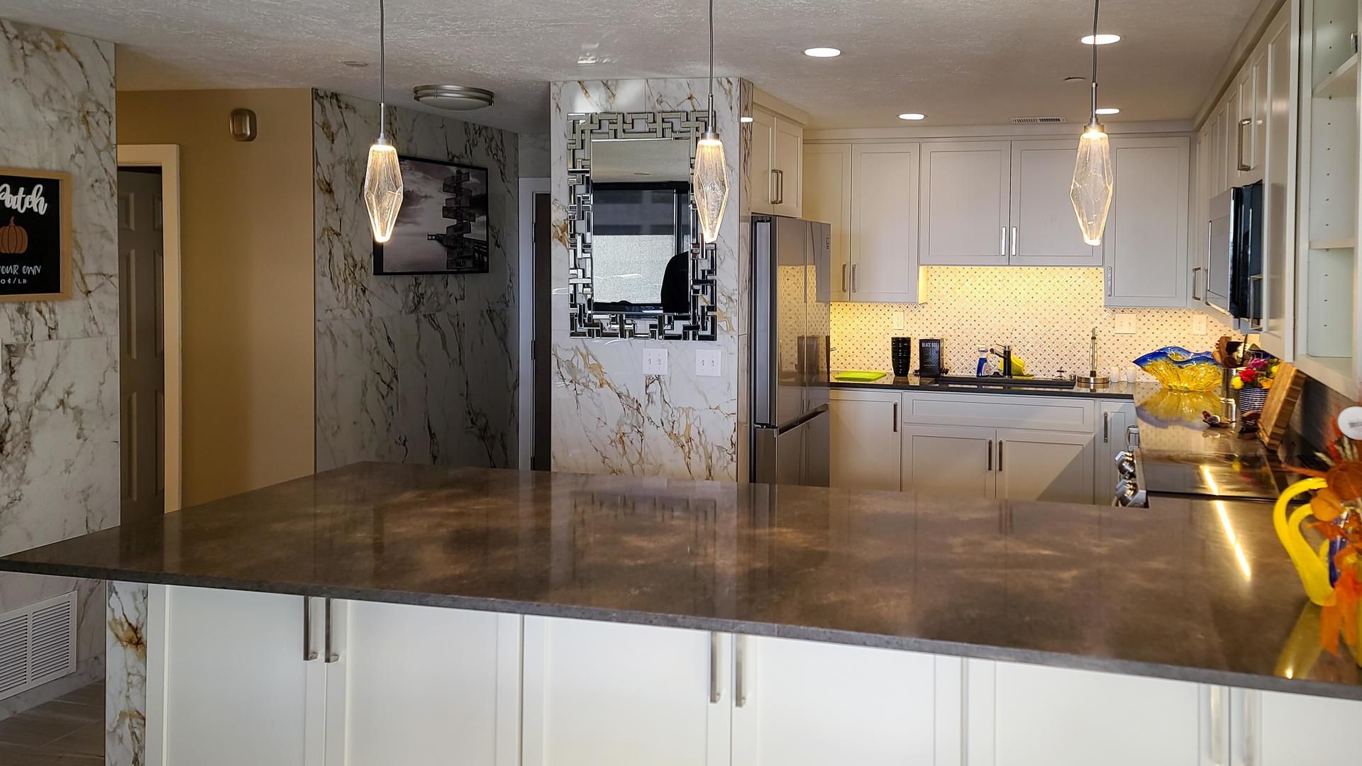 A kitchen with a large island and white cabinets