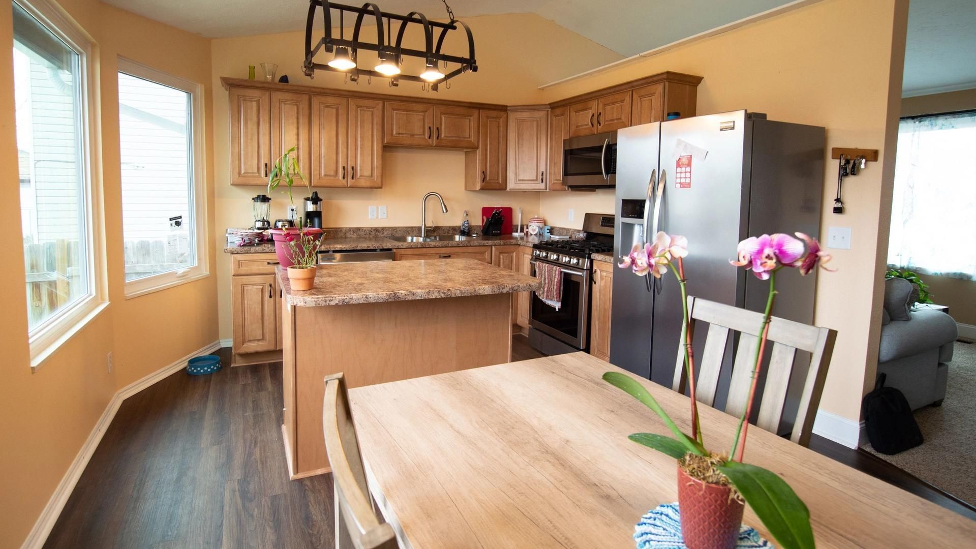 A kitchen with a table and chairs and a refrigerator.