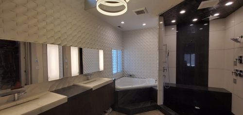 A bathroom with two sinks , a tub , and a shower.