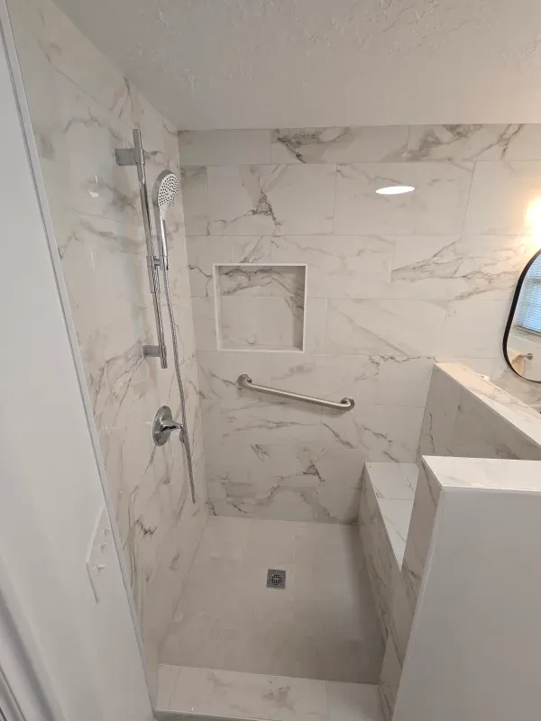 A bathroom with a walk in shower and a mirror.