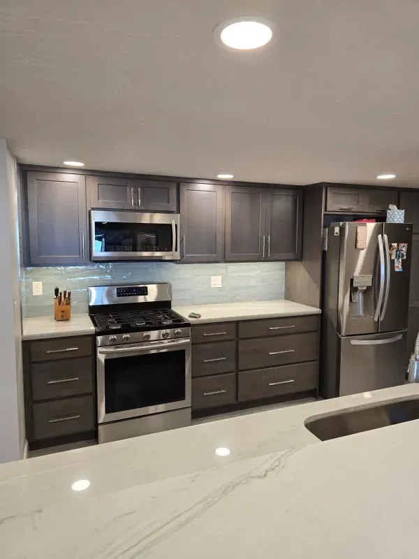 A kitchen with stainless steel appliances and gray cabinets