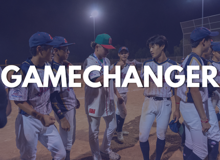 Baseball players in blue and white uniforms walking on a lit field with “GAMECHANGER” text overlaid