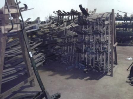 Estantes llenos de varias piezas de vehículos metálicos en un almacén.