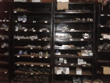 Estantes llenos de diversas piezas de hardware en una habitación oscura.