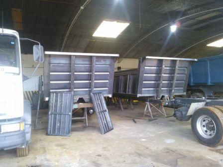 Cajas de camiones en construcción dentro de un taller, con marcos y paneles metálicos.