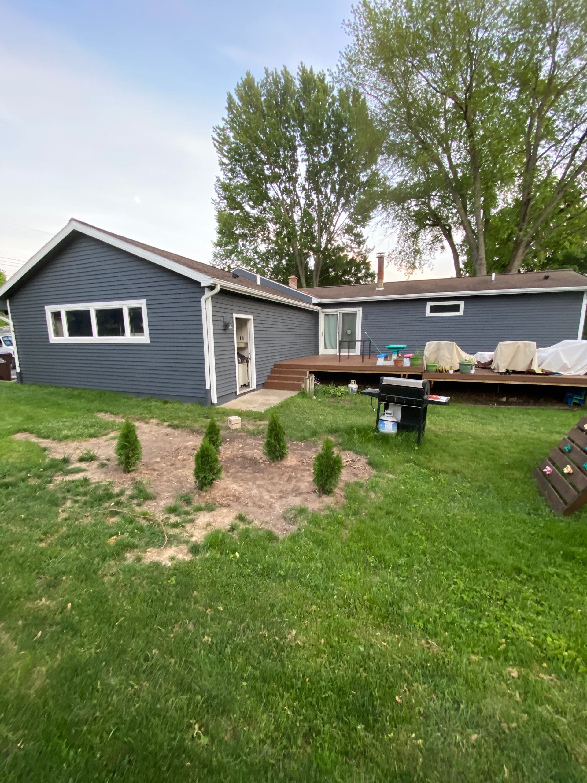 A house with a barbecue grill in the backyard.