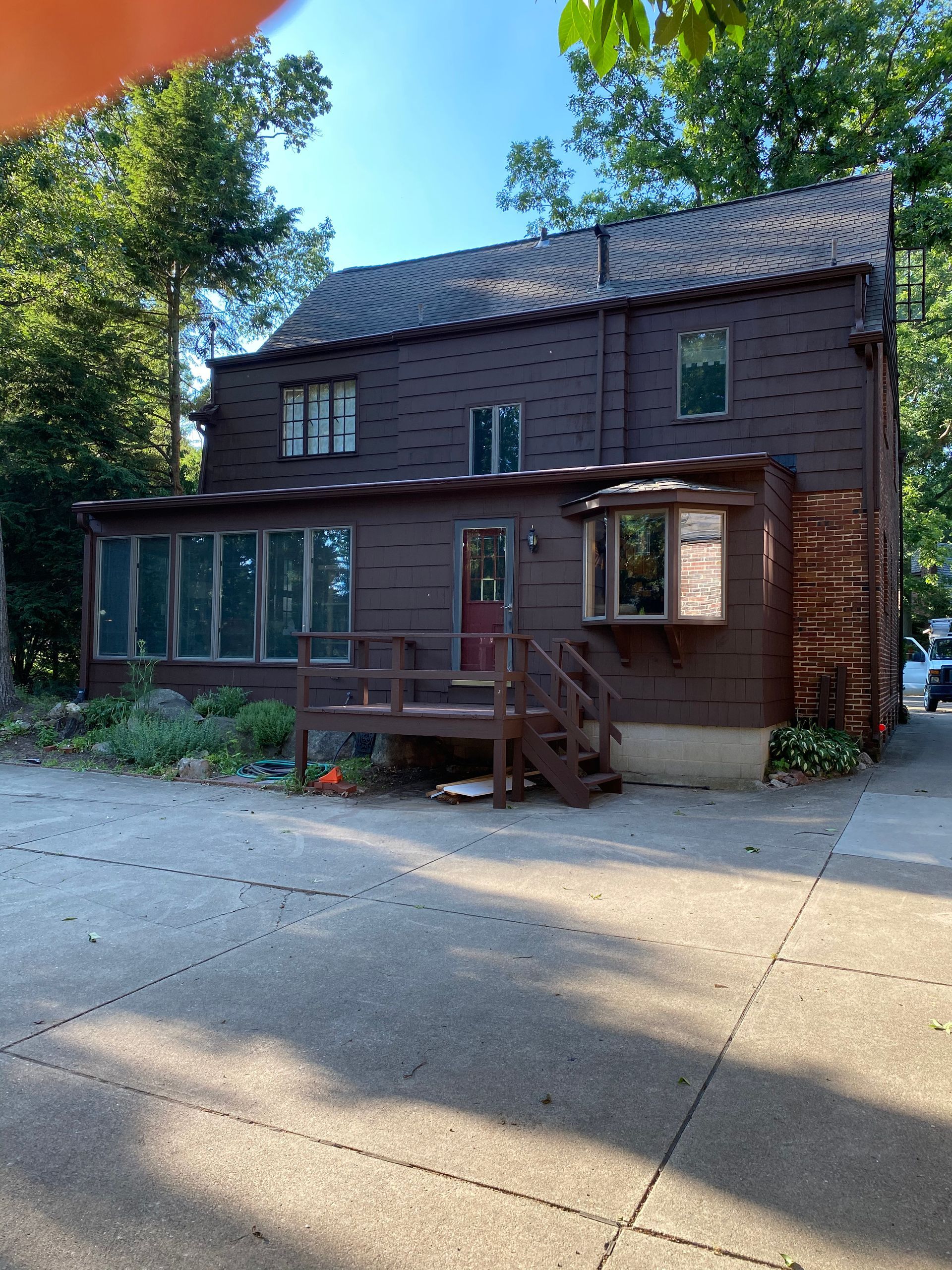 A brown house with a black roof and a red door