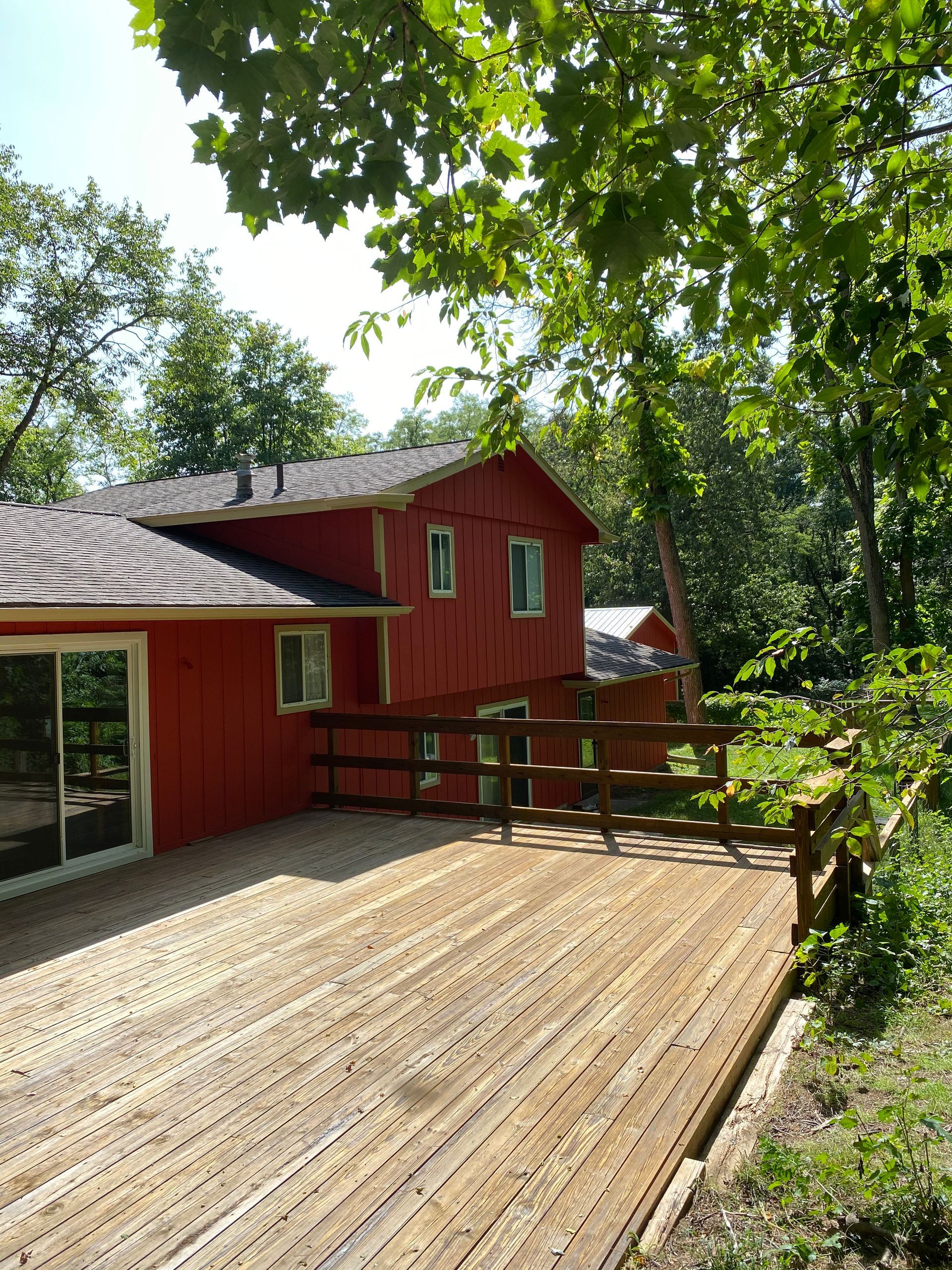 A red house with a wooden deck in front of it