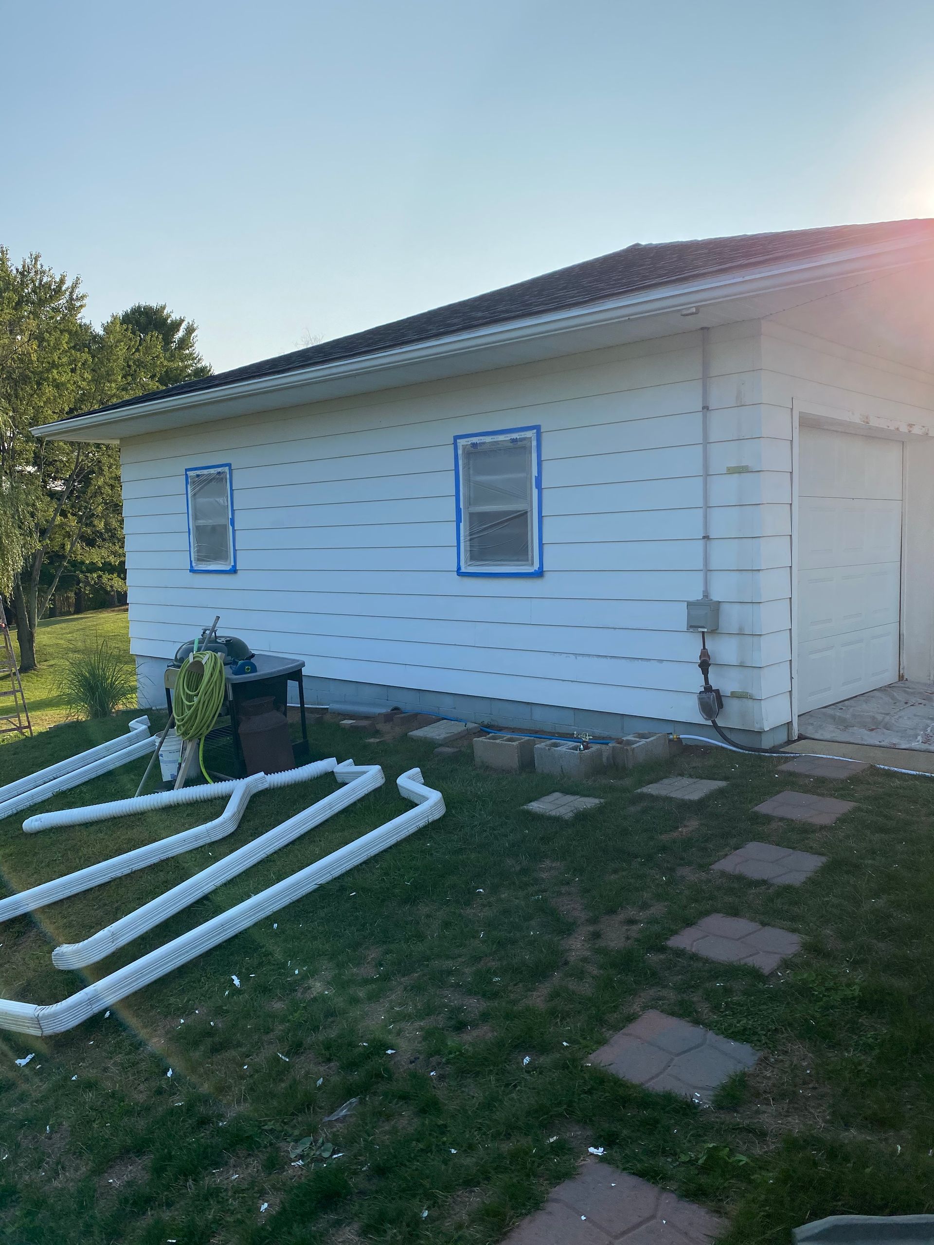 A white house with a lot of white pipes in front of it.