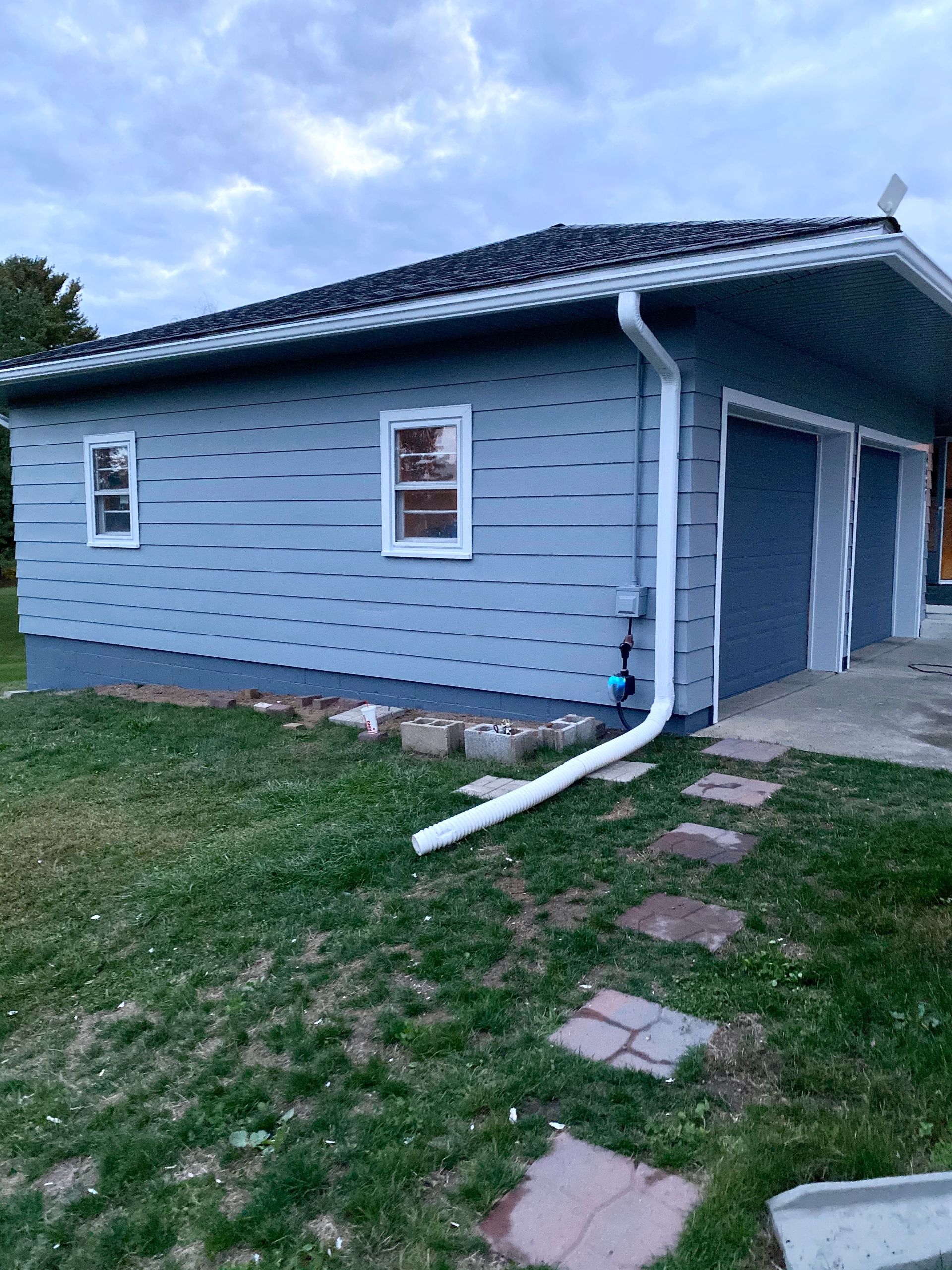 A house with a garage and a gutter on the side of it.