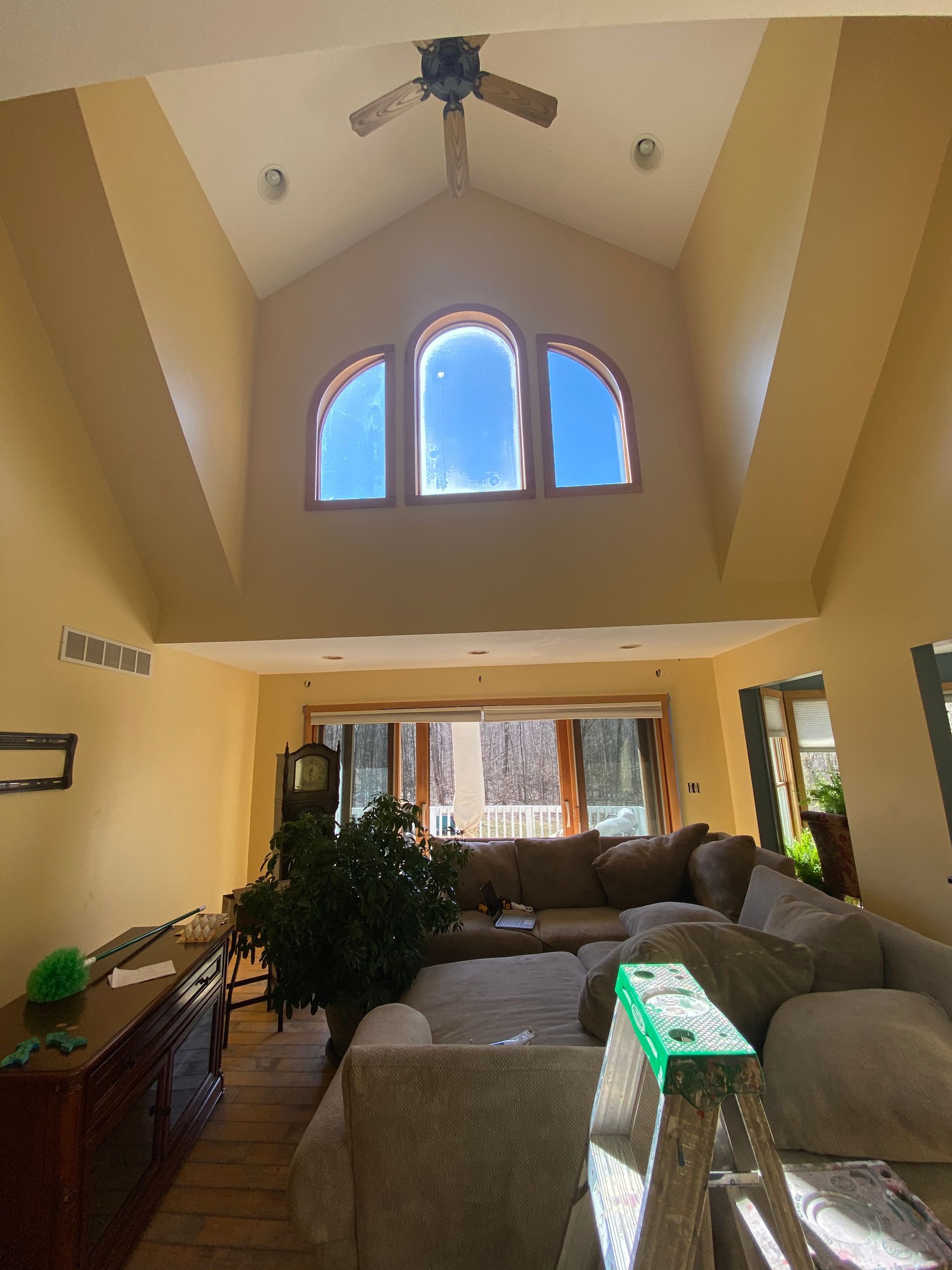 A living room with a lot of furniture and a ceiling fan.