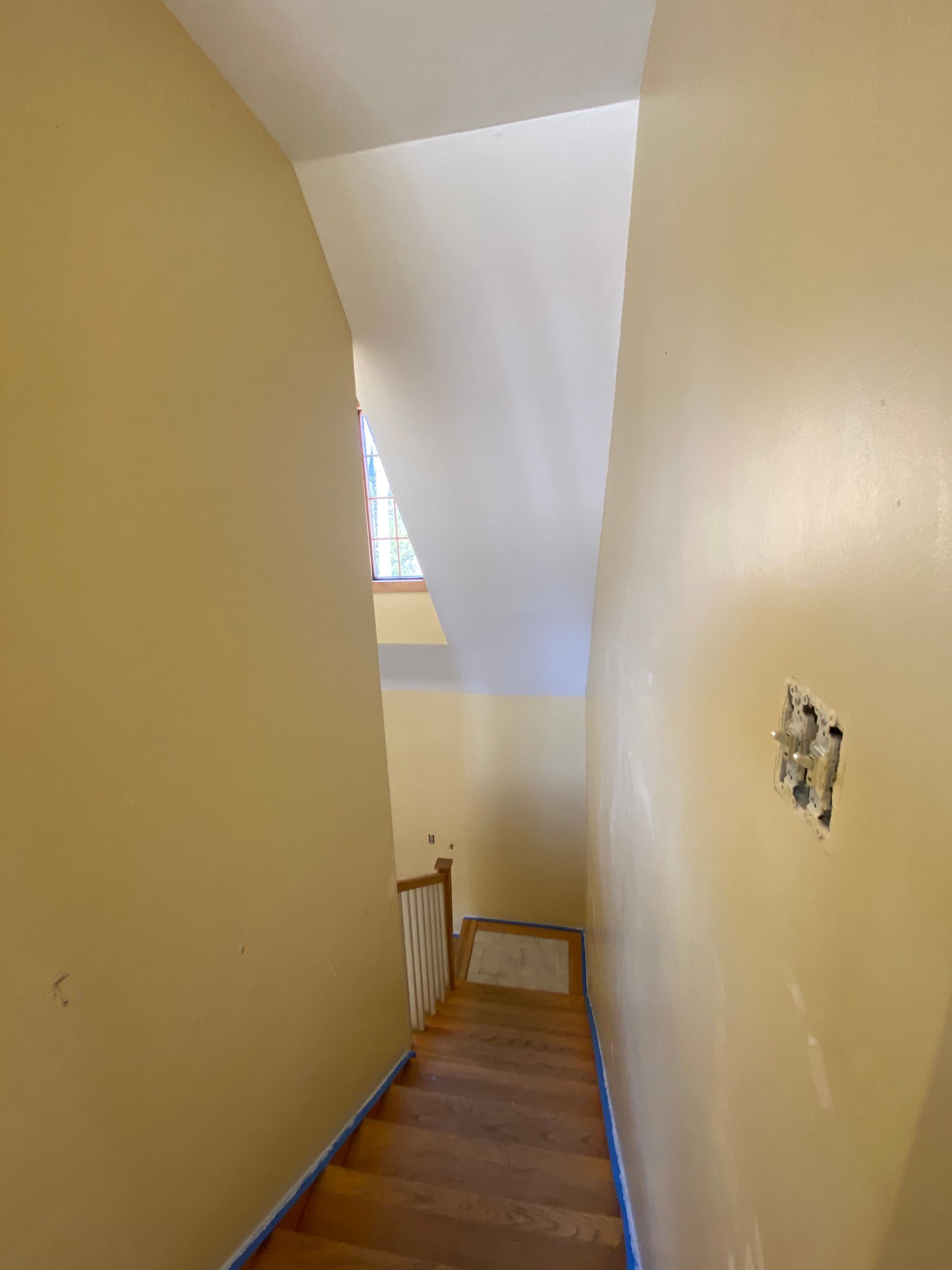 A hallway with stairs leading up to the second floor of a house.