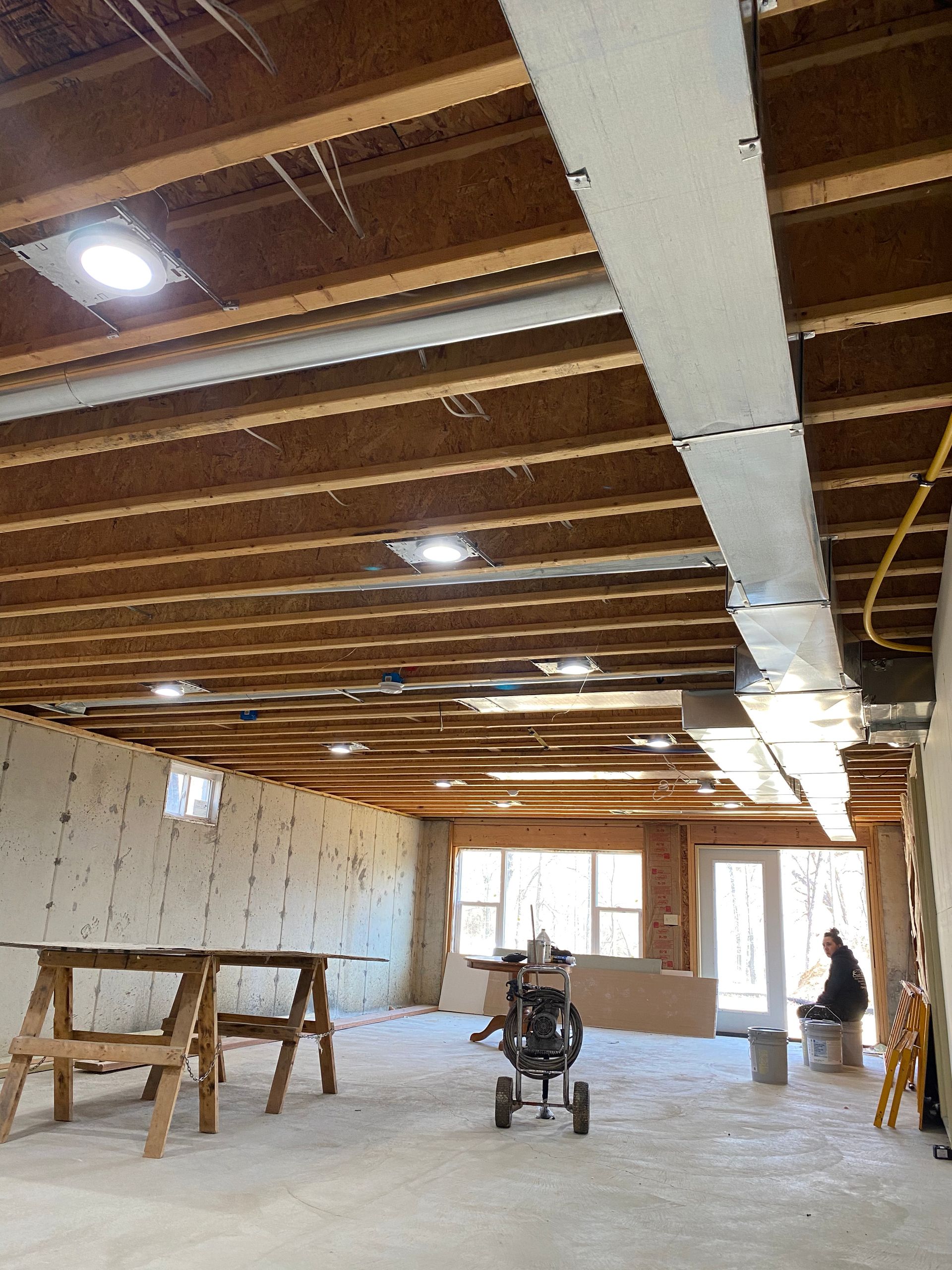A stroller is parked in the middle of a room under construction