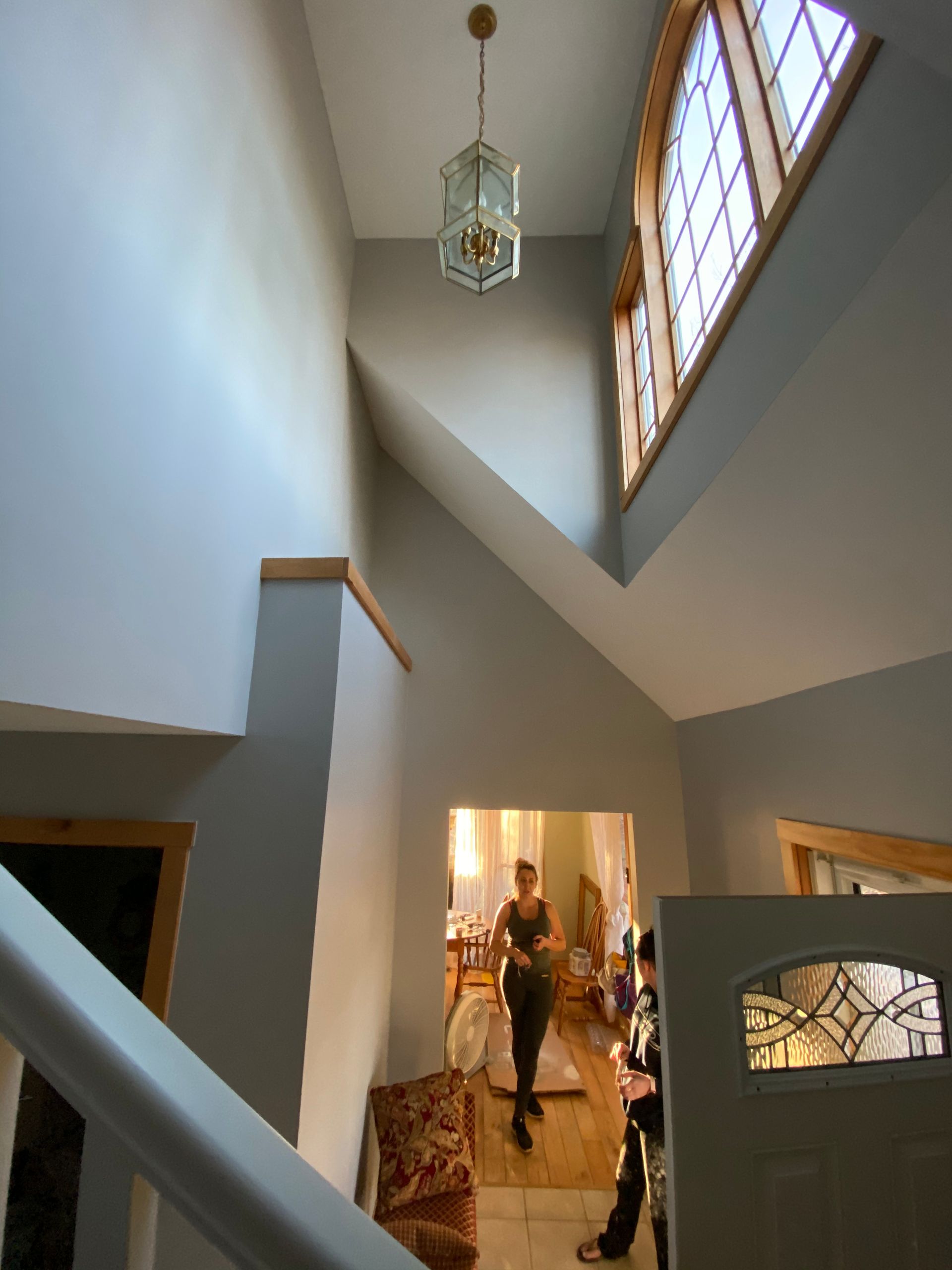 A woman is walking down a staircase in a house