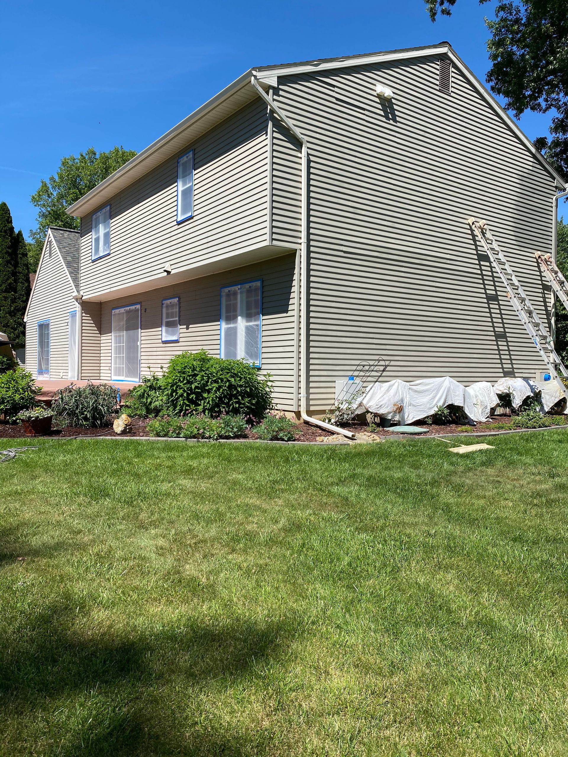 A house is being painted on a sunny day.