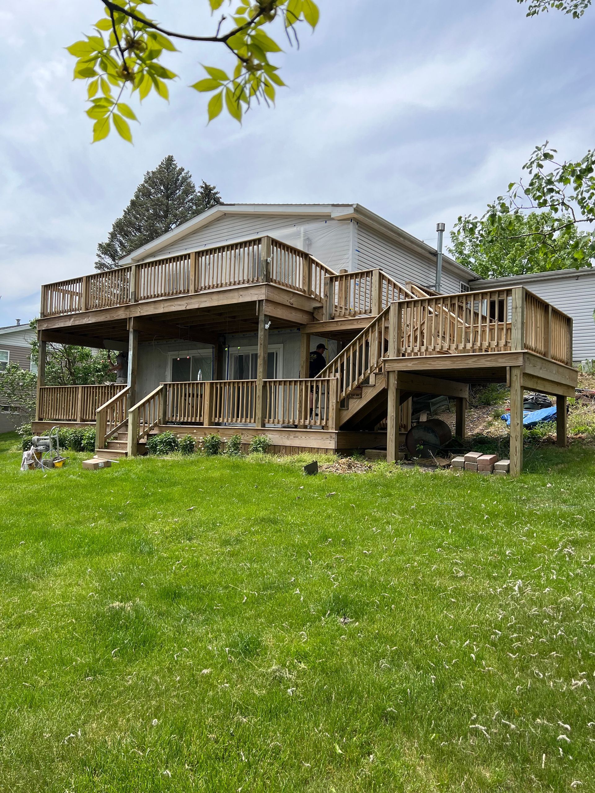 The back of a house with a large deck and stairs.
