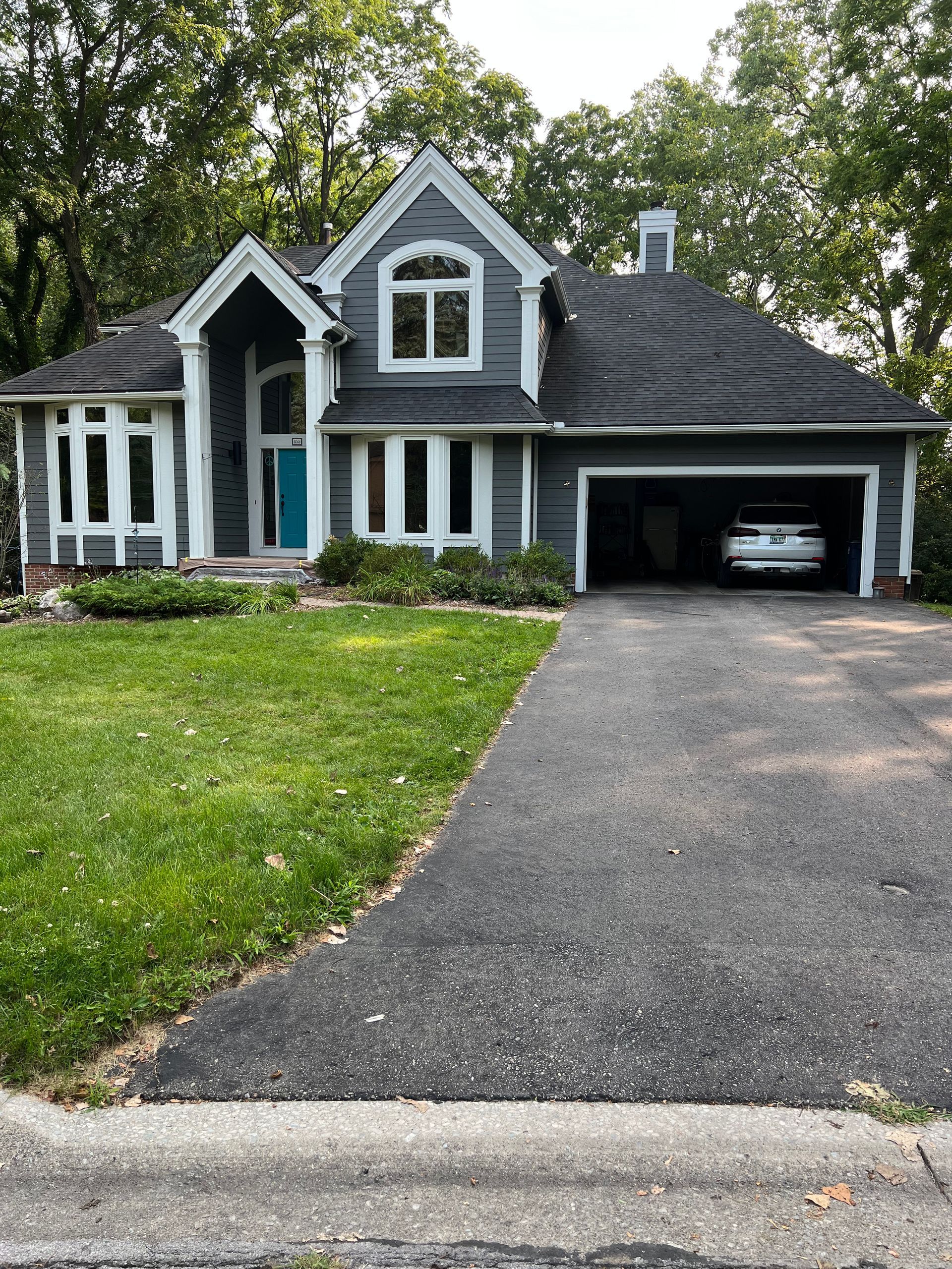 A large house with a car parked in the driveway.