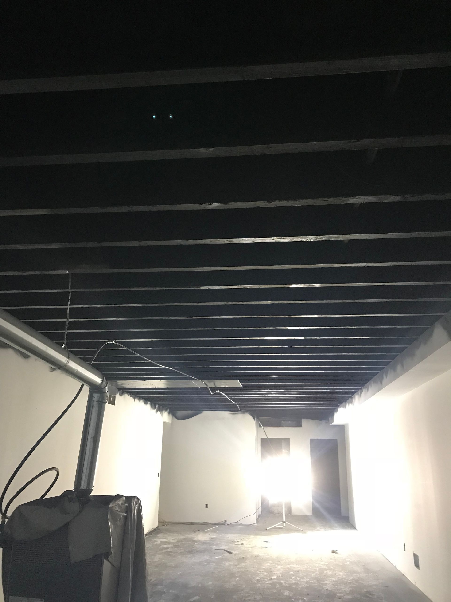 An empty room with a black ceiling and white walls