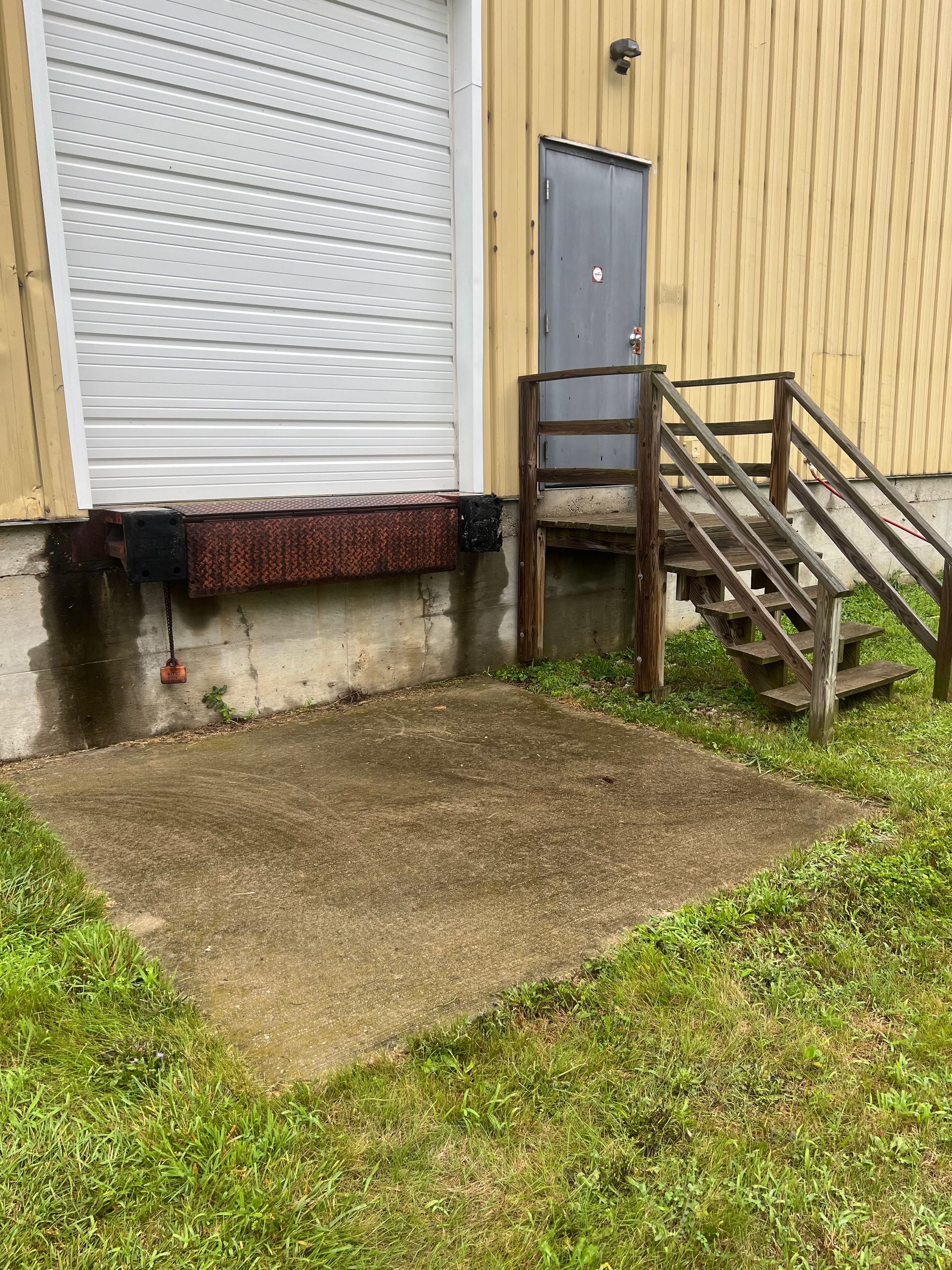 A building with a garage door and stairs leading up to it.