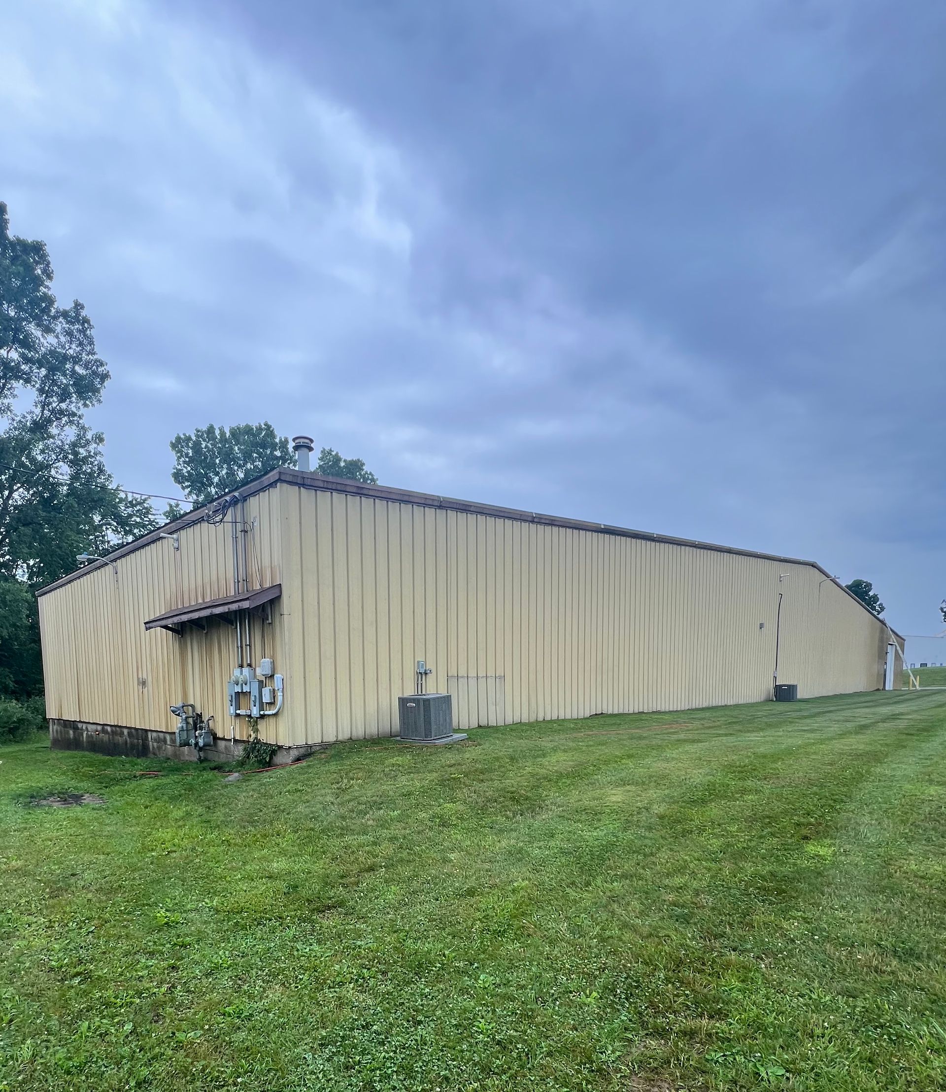 A large building is sitting in the middle of a grassy field.