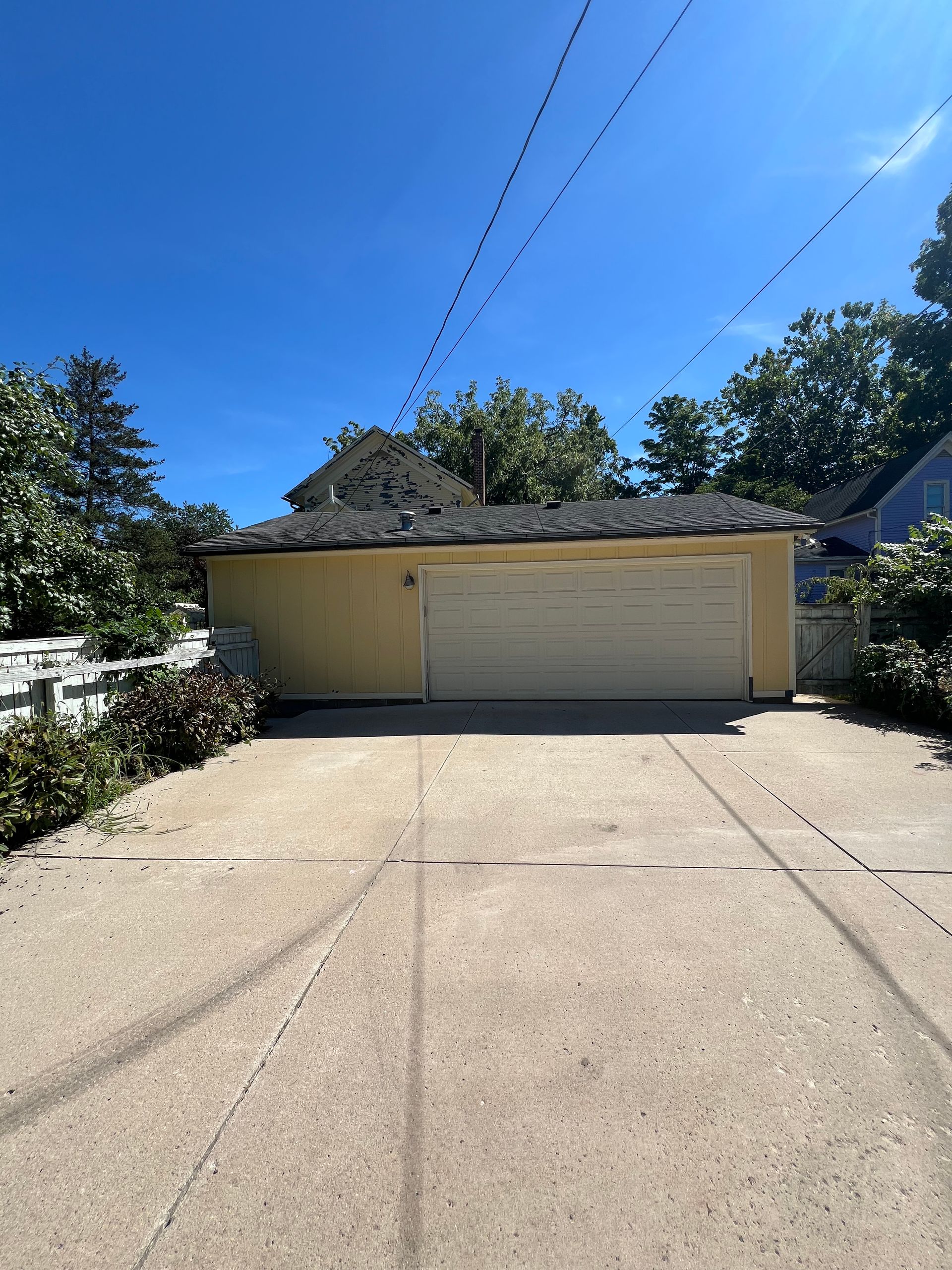 A driveway leading to a garage with a blue sky in the background