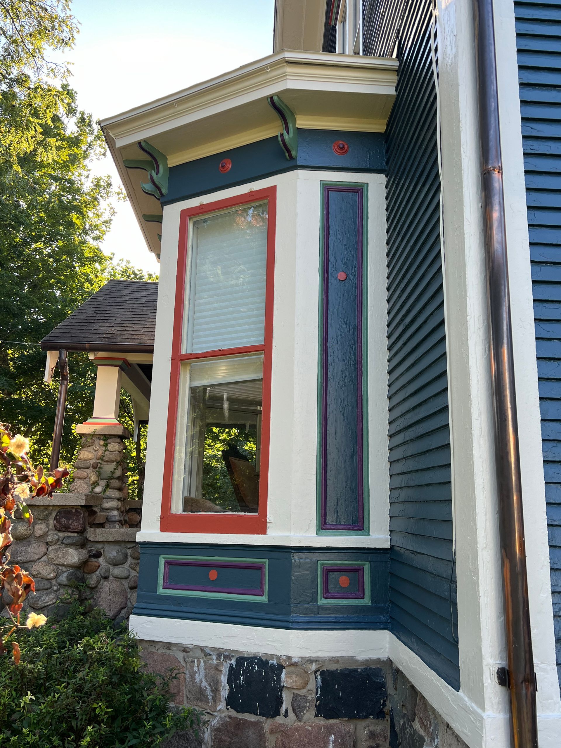 A blue and white house with a bay window