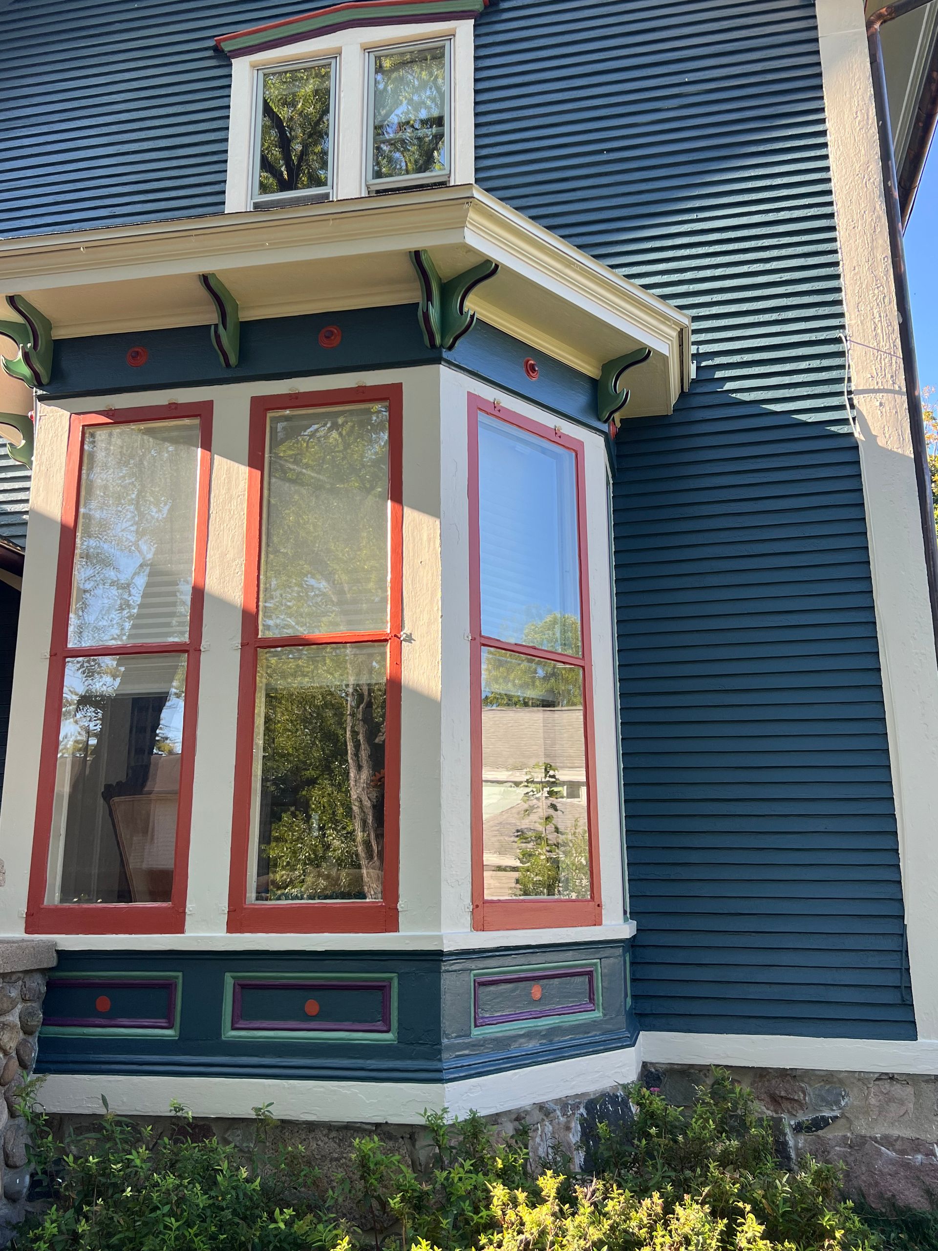 A blue and white house with a large bay window