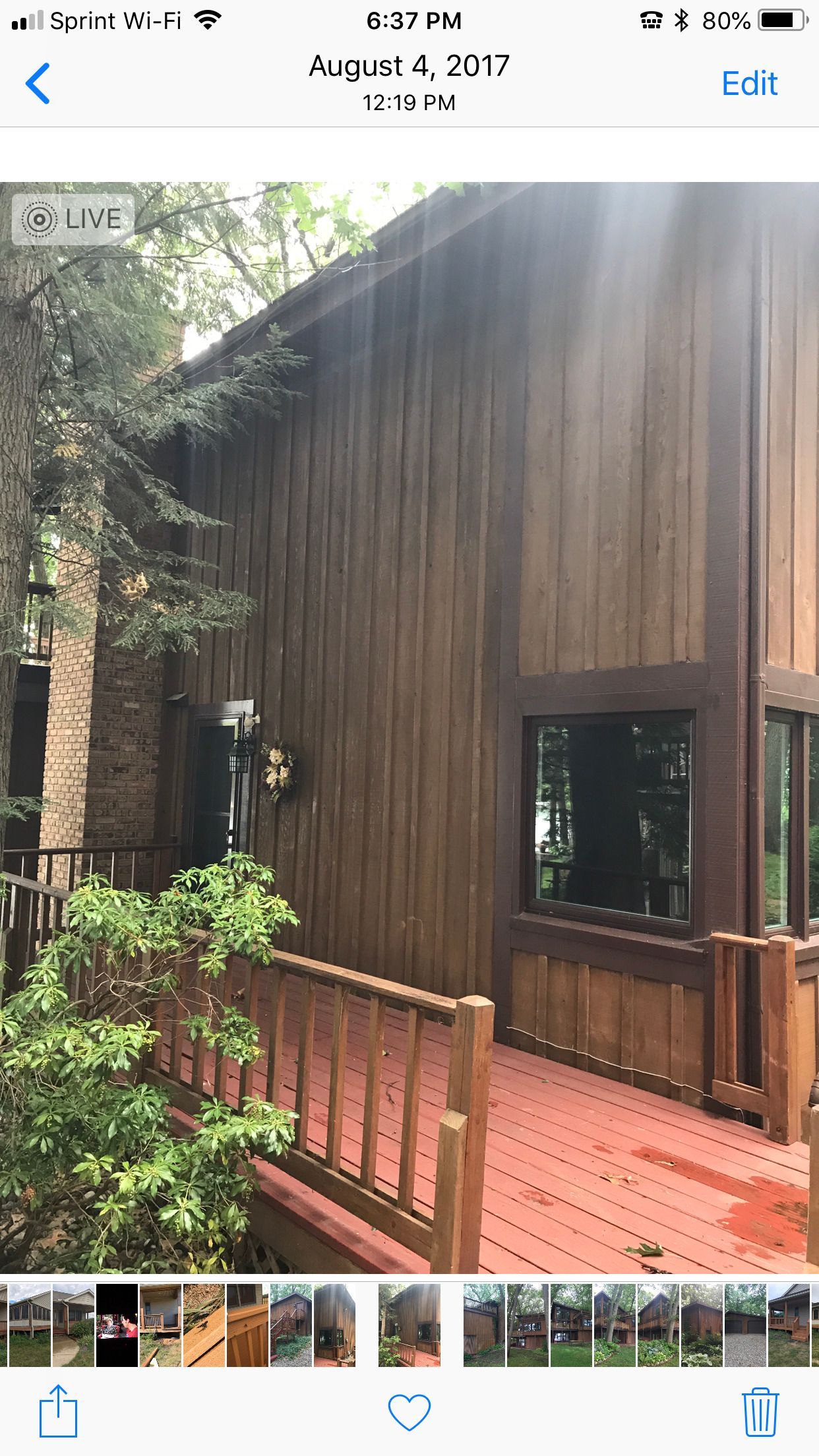 A picture of a wooden house with a red deck.