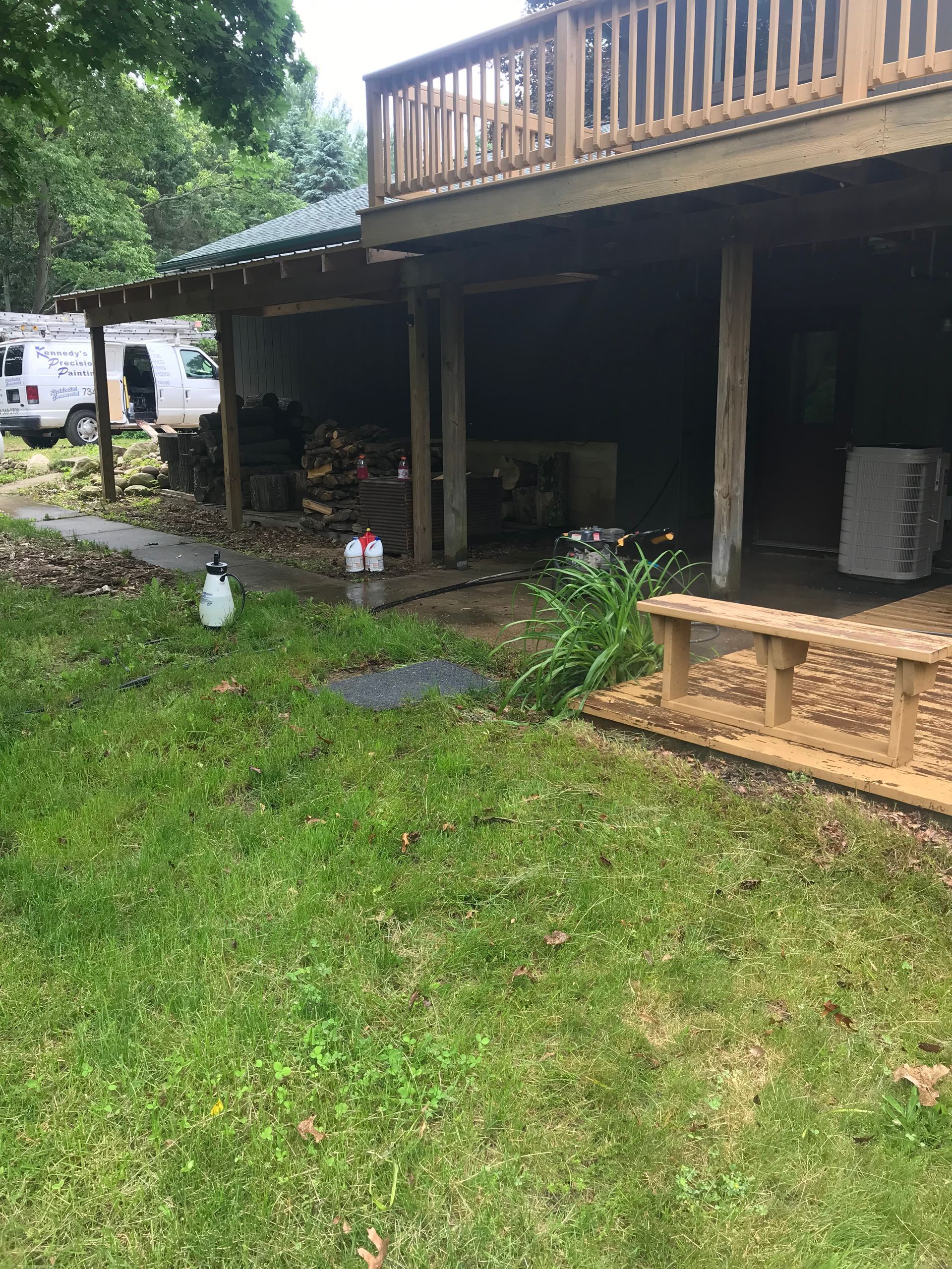 A house with a wooden deck and a picnic table in the backyard.