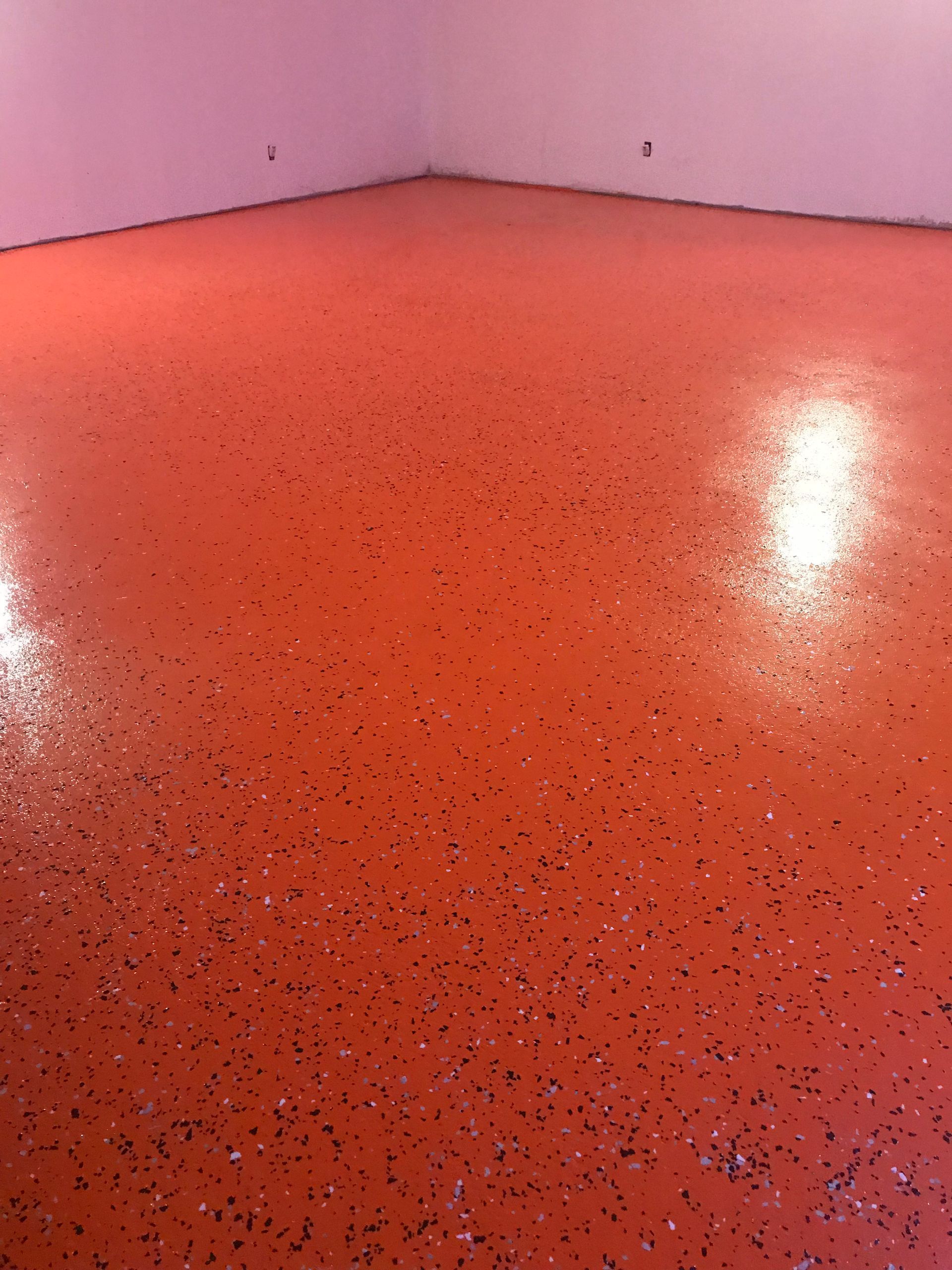 A room with a red floor and a pink wall.