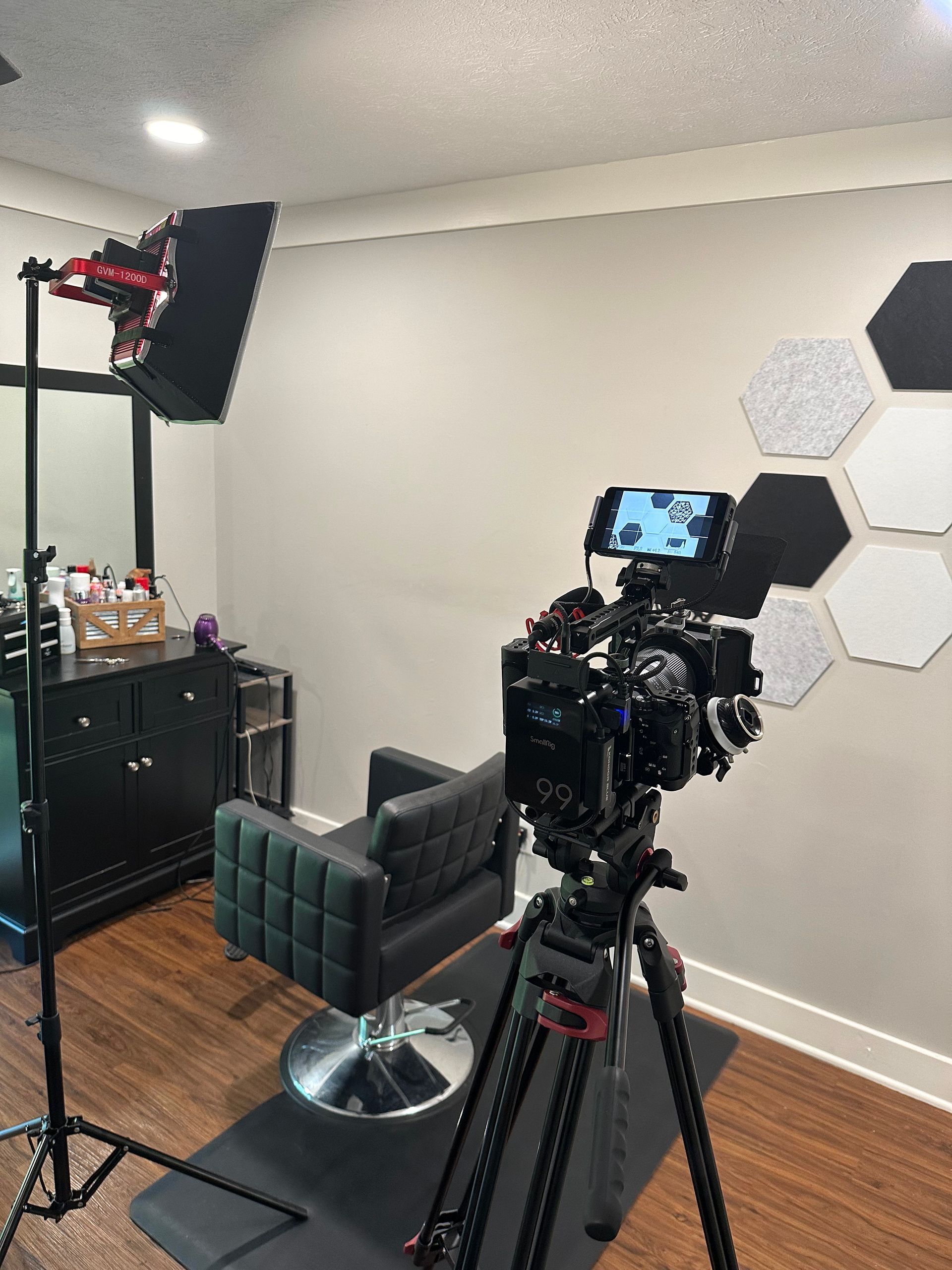 A four-piece band performs on a stage with large windows, warm lighting, and music equipment in an industrial-style room.