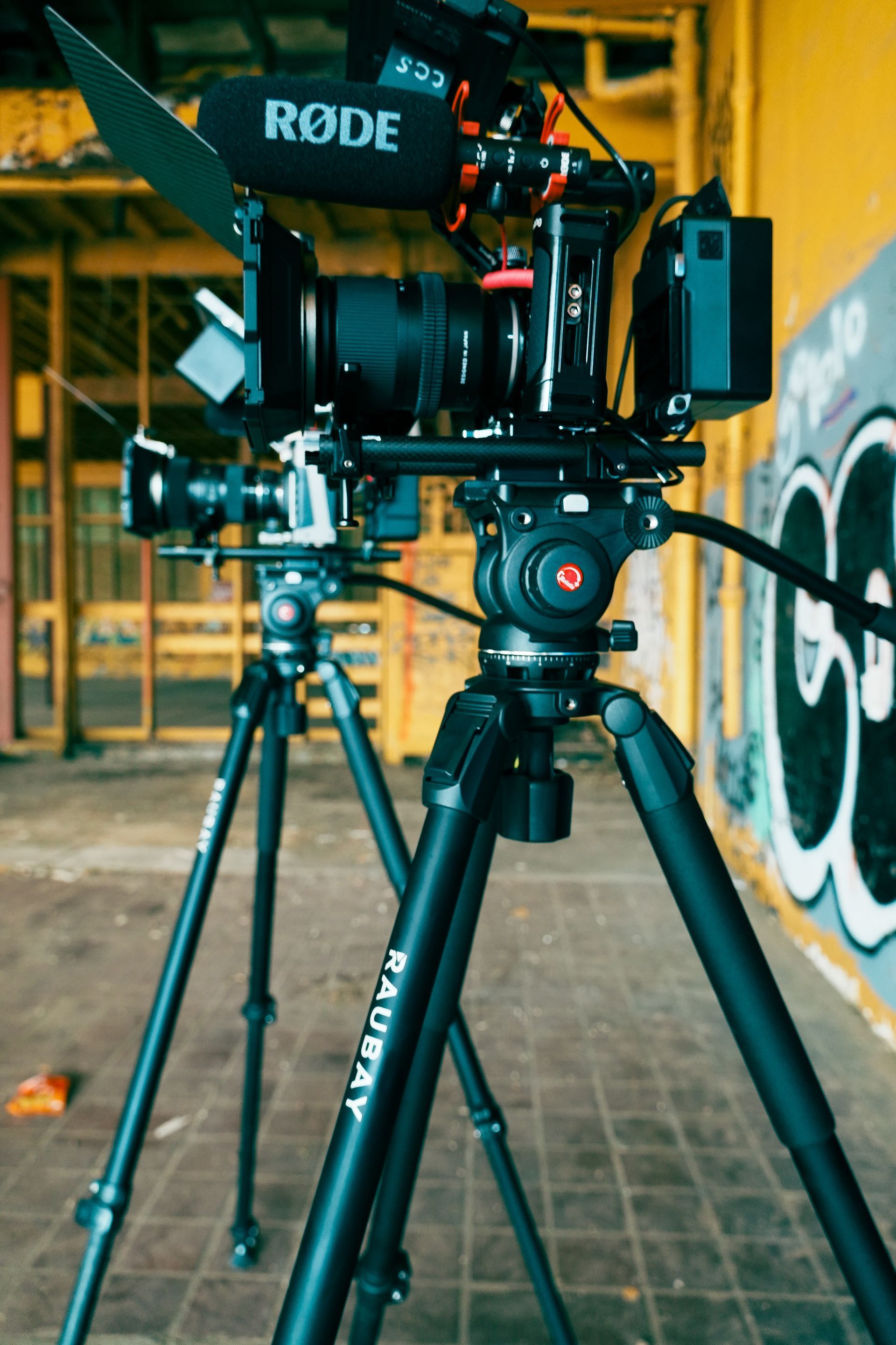 A four-piece band performs on a stage with large windows, warm lighting, and music equipment in an industrial-style room.