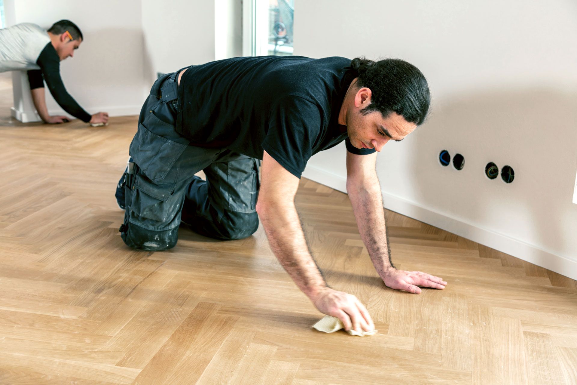 Wooden floor, warm sunlight shining through a door, plants in background