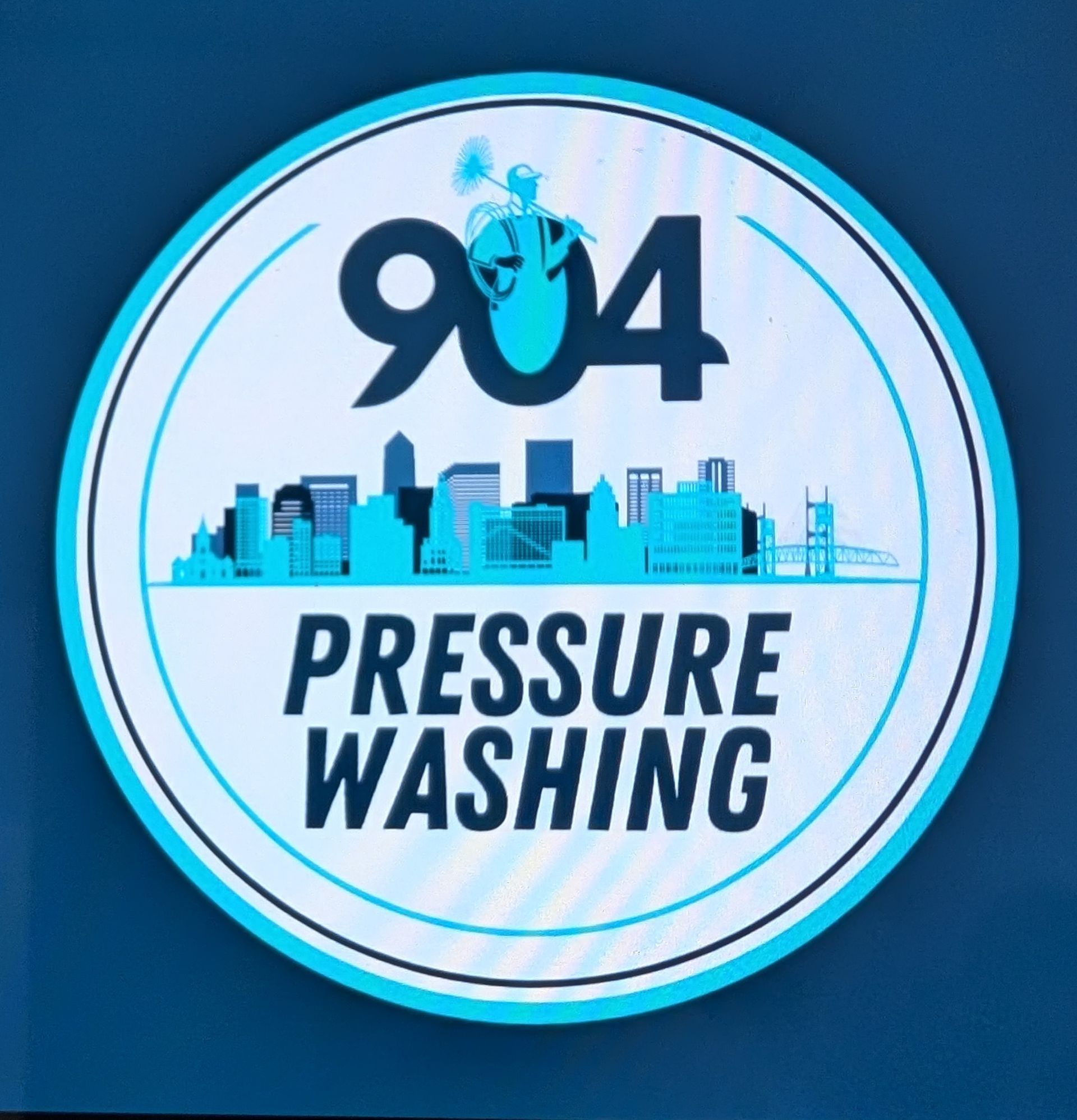 Logo for 904 Pressure Washing: Blue and white circle with city skyline and text. Includes a person pressure washing.