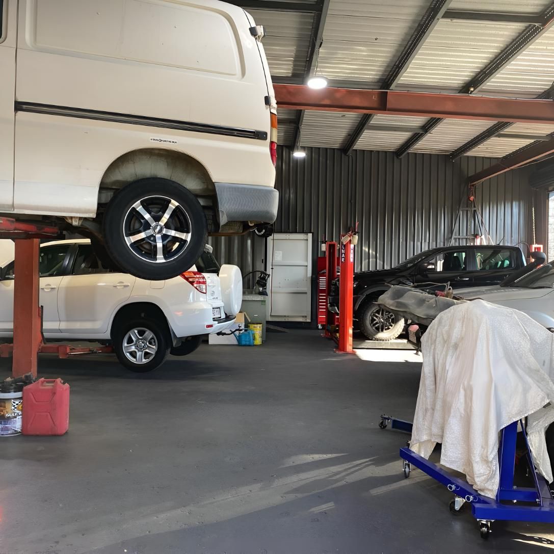 A Van is Sitting on Top of a Car Lift in a Garage — Coolangatta Automotive in Coolangatta, QLD