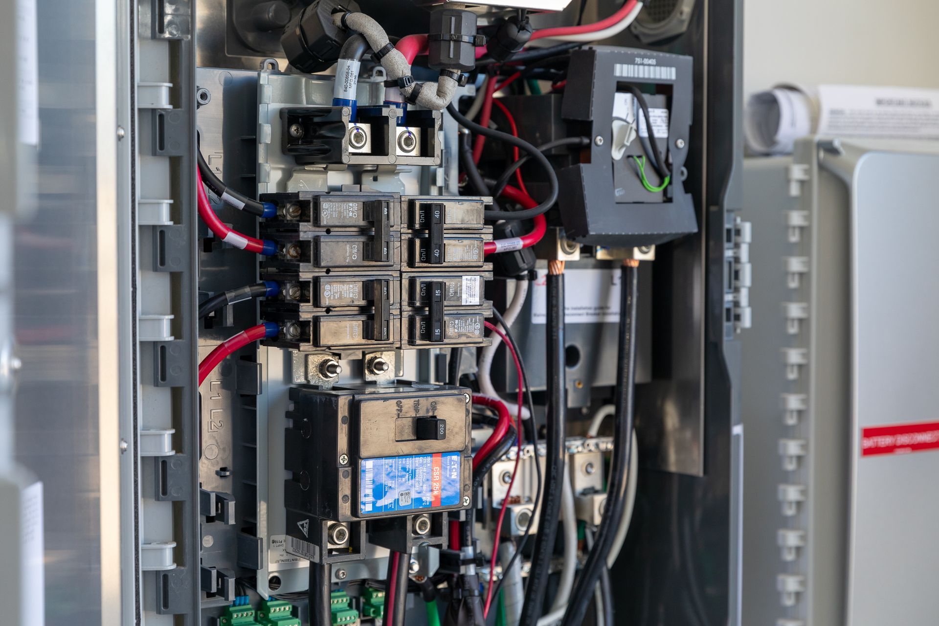 A close up of a electrical box with a lot of wires coming out of it.