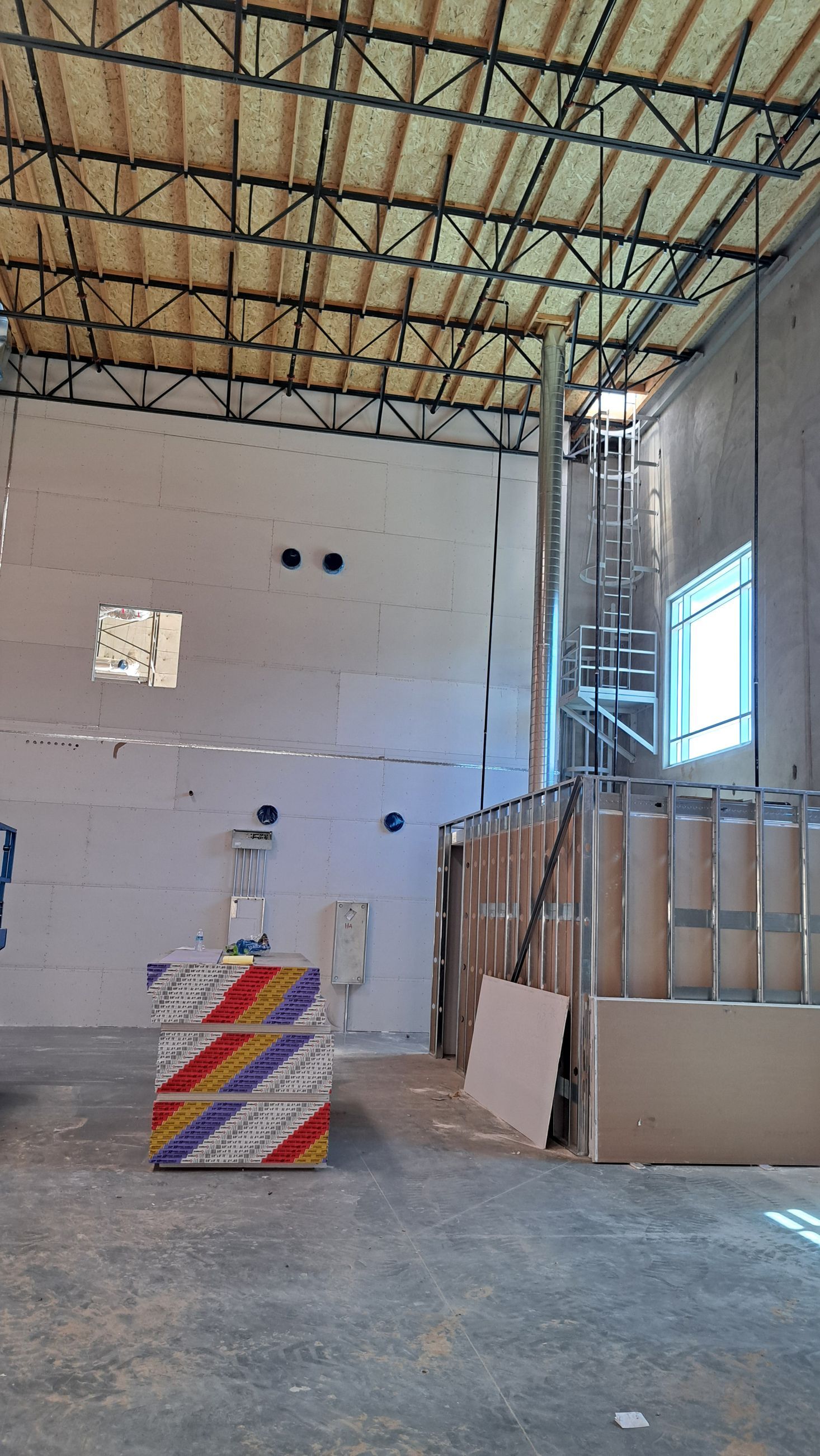 A large empty room with a ceiling and a staircase.