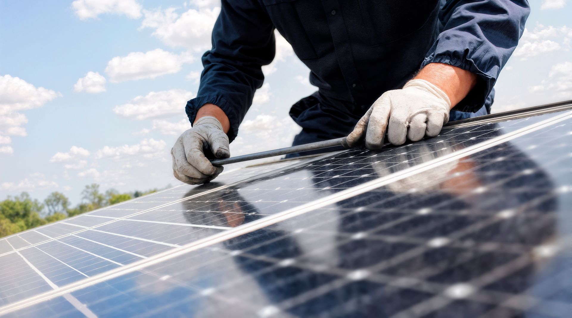 Person in gloves installing solar panels on a rooftop.