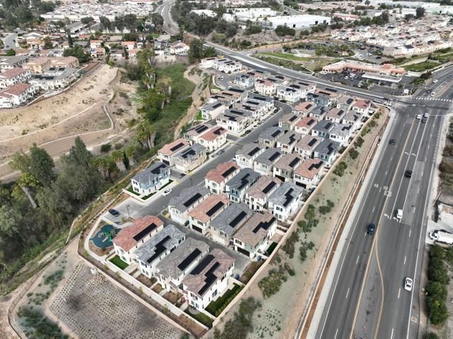 An aerial view of a residential area with lots of houses and a highway.