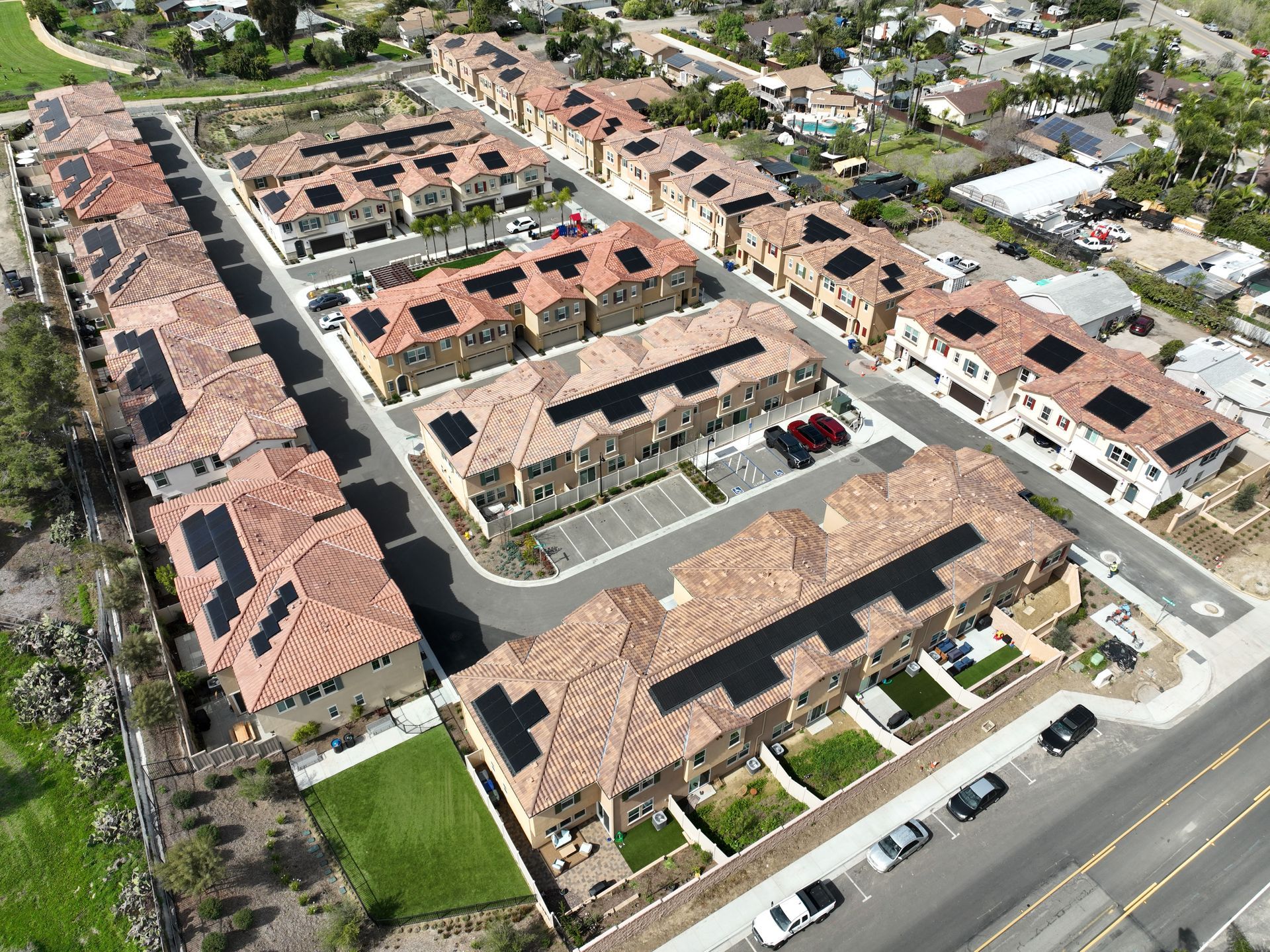 An aerial view of a row of houses with solar panels on the roofs.