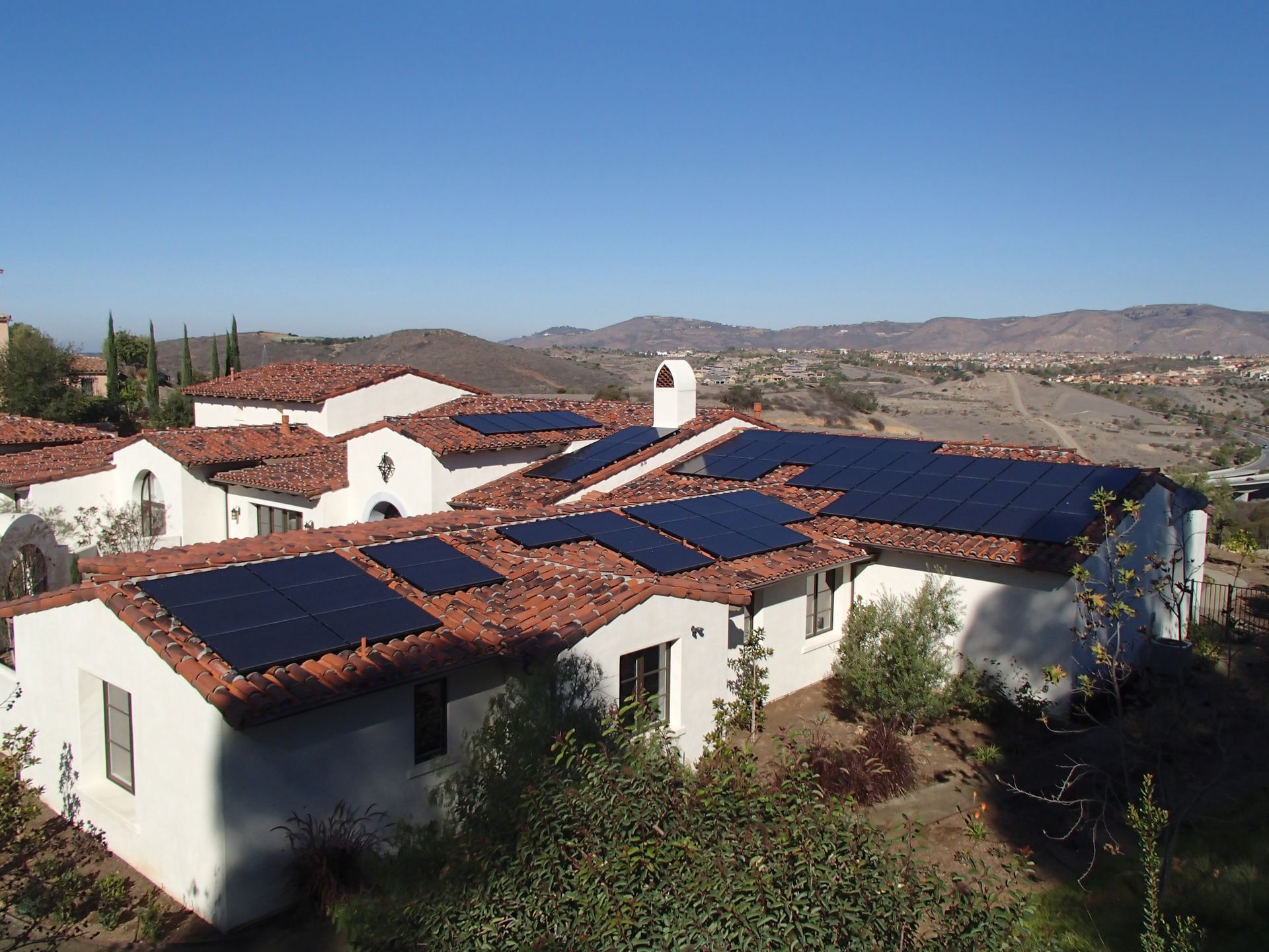 A large white house with solar panels on the roof