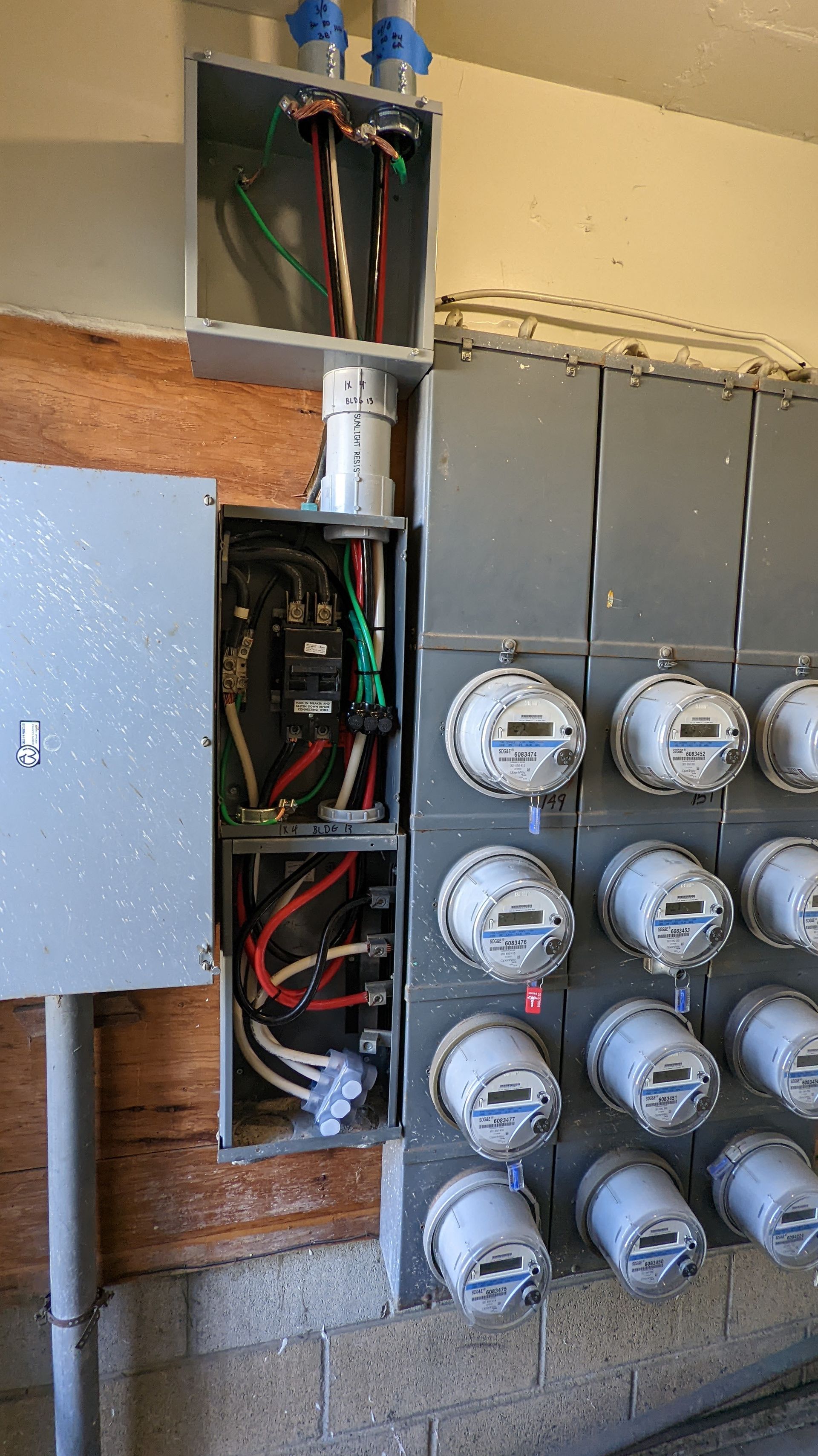 A row of electrical meters are sitting next to each other on a wall.