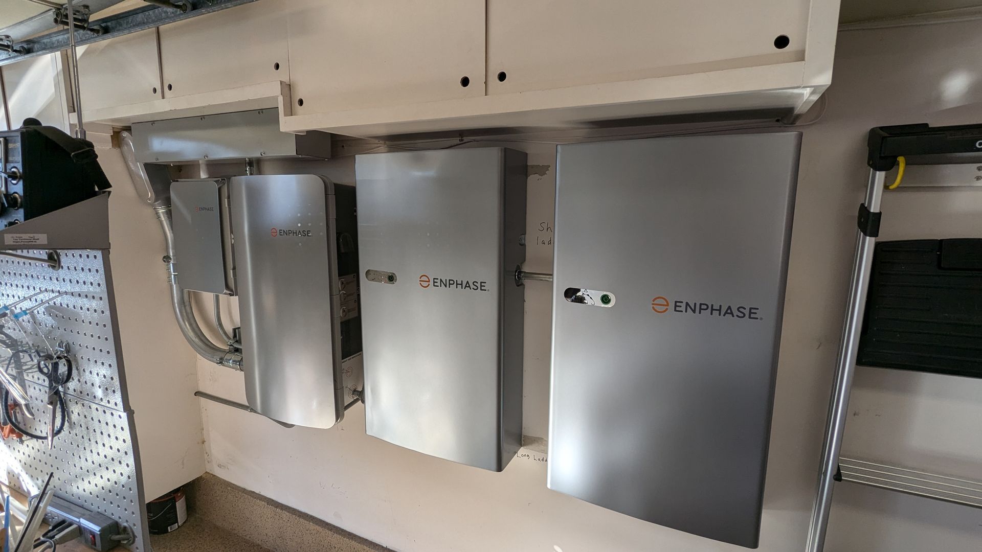 A row of metal boxes hanging on a wall in a garage.